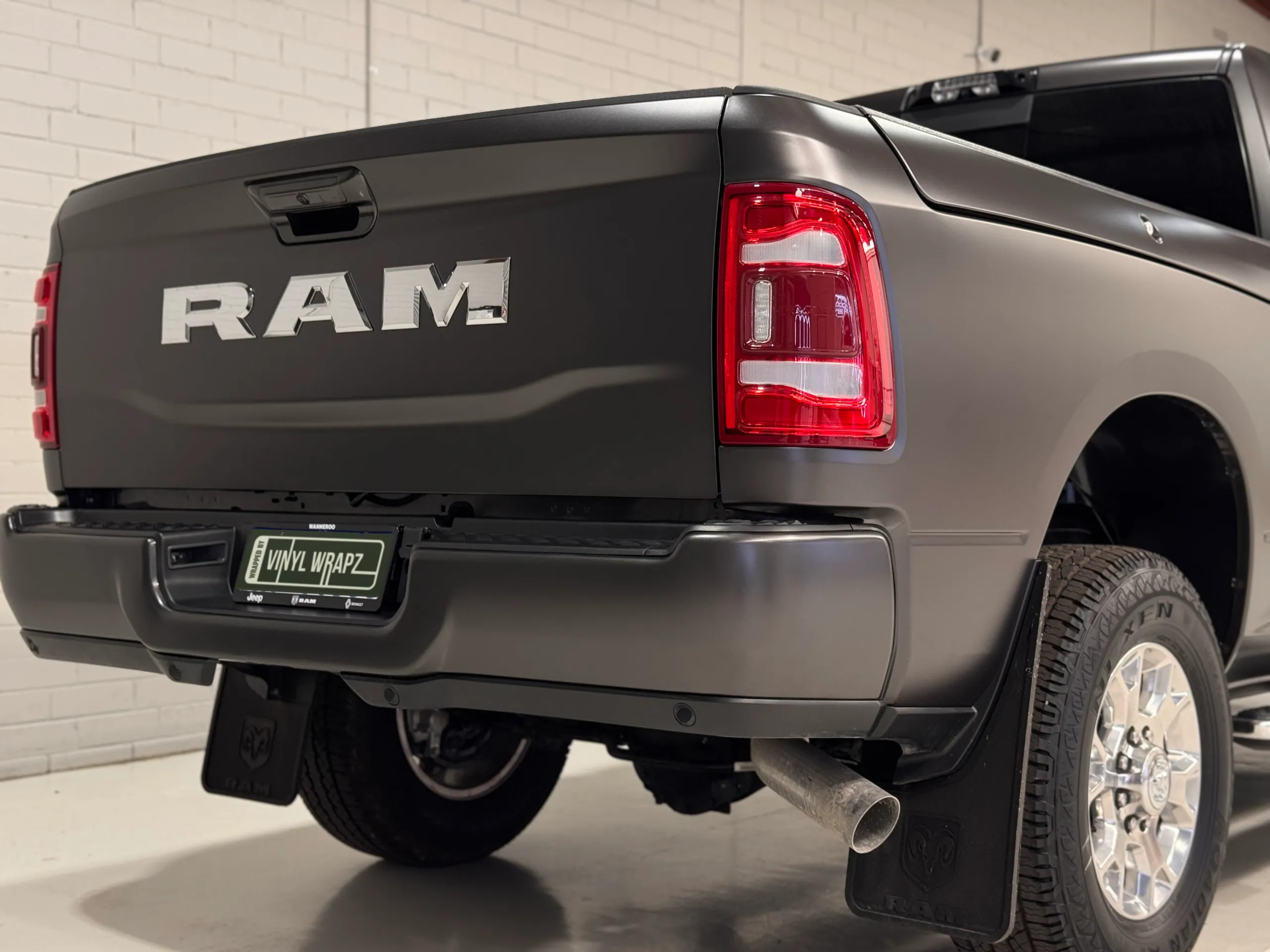 Matte grey Ram 2500 tailgate, rear bumper and rear wheel in the workshop