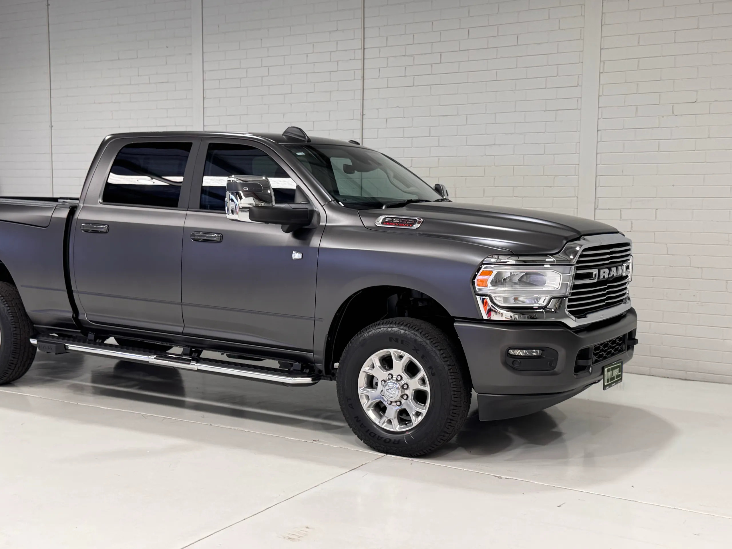 Matte grey Ram 2500 cab, front wheel and grille in the workshop