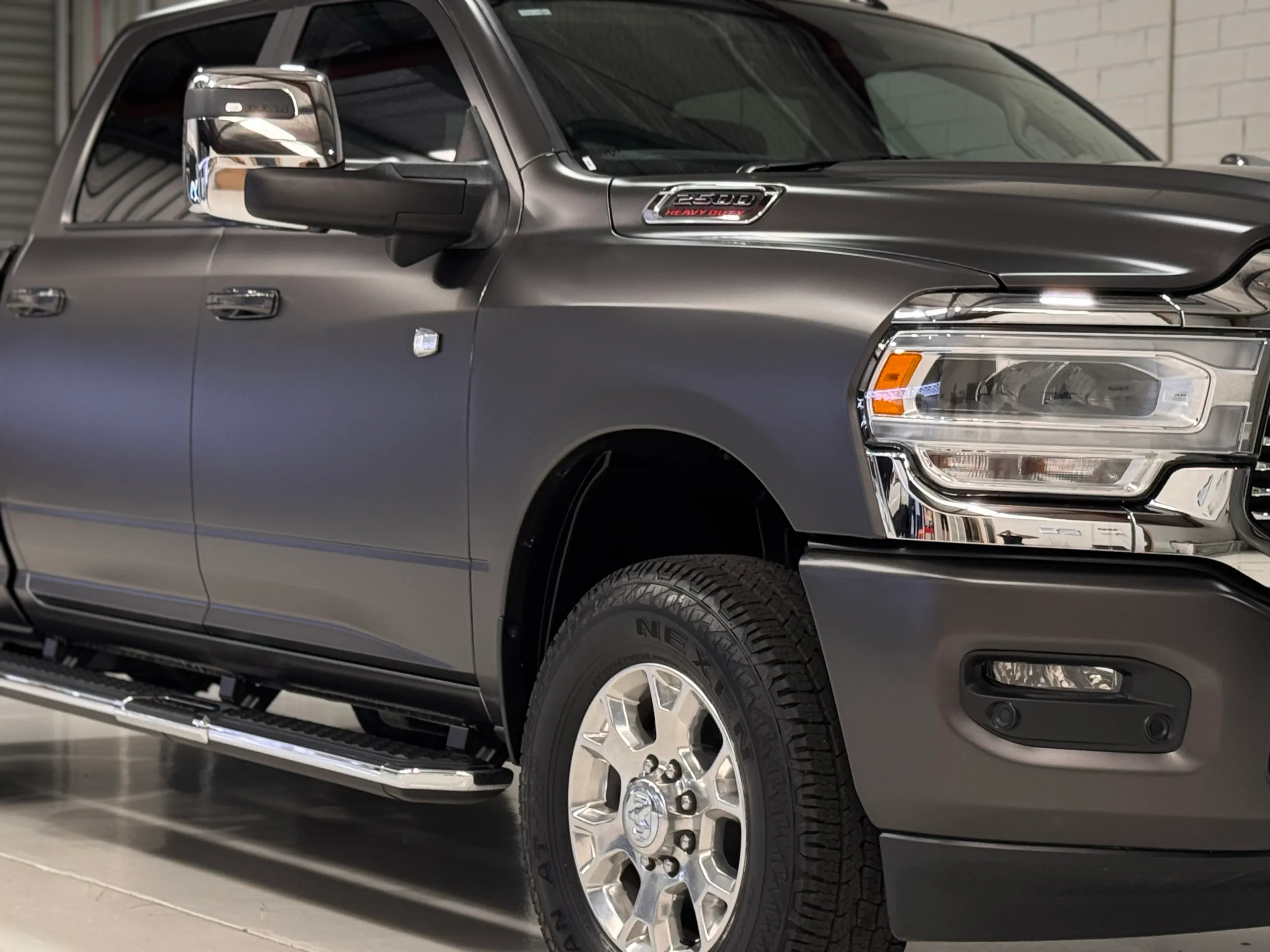 Close view of the matte grey Ram 2500 front guard, headlight and cab