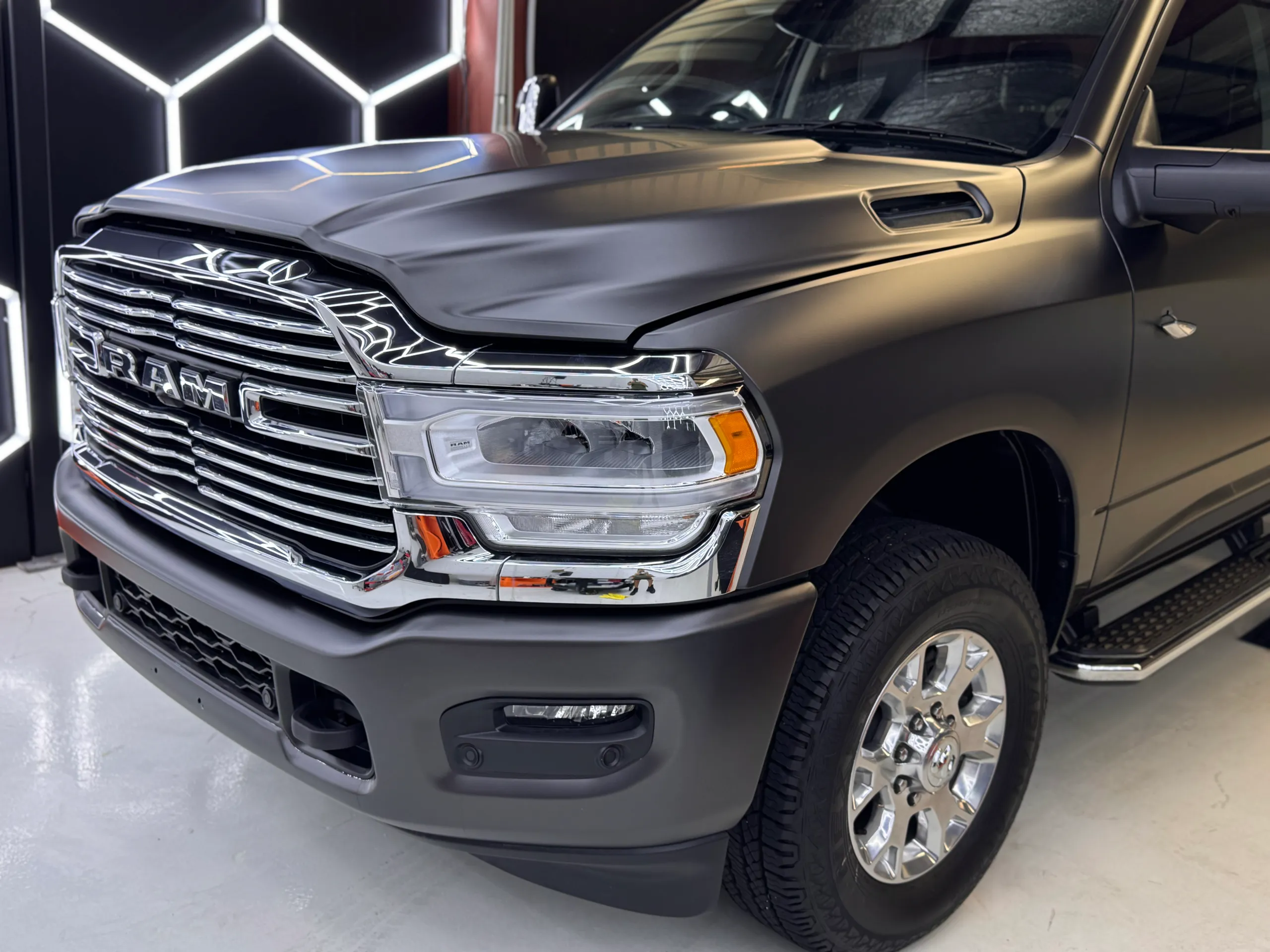 Satin dark grey Ram 2500 front quarter with a chrome grille and front wheel