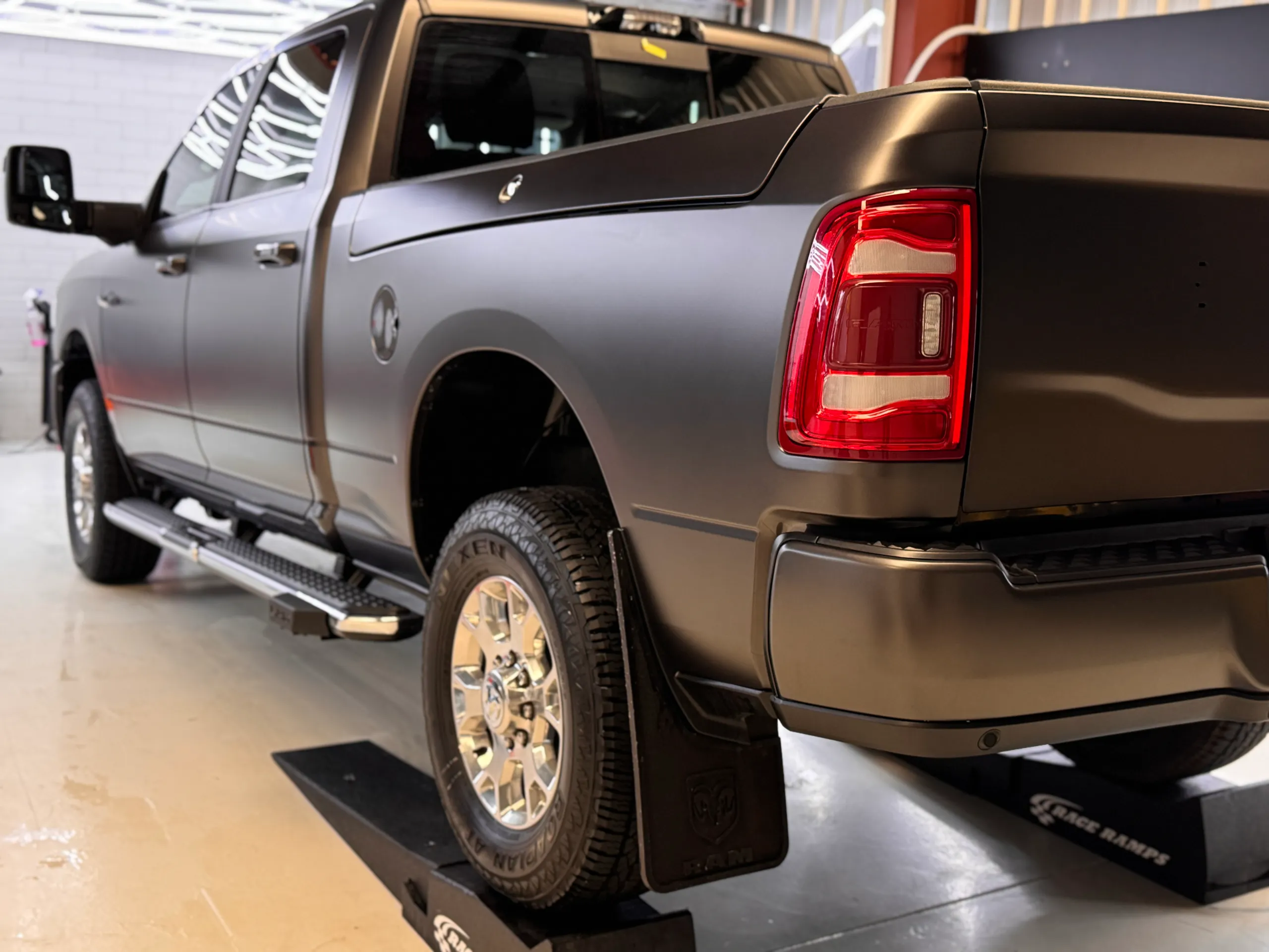 Satin dark grey Ram rear quarter and chrome wheel in the workshop