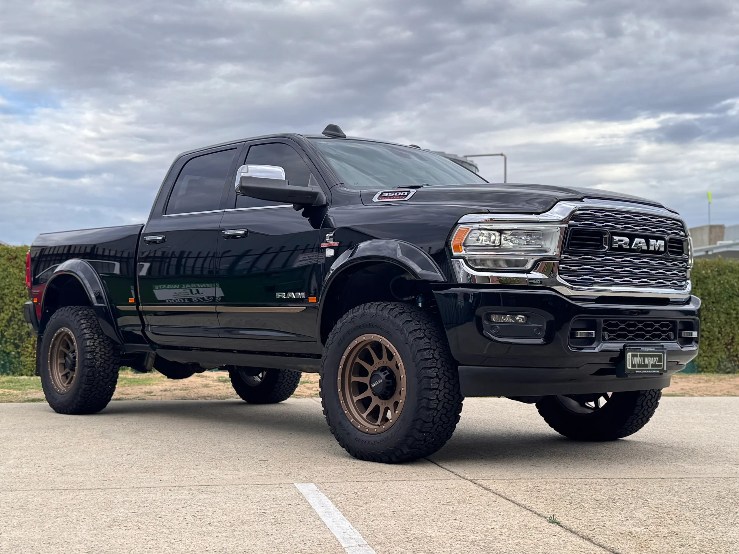 Black Ram 3500 with bronze wheels and large off-road tyres parked outdoors