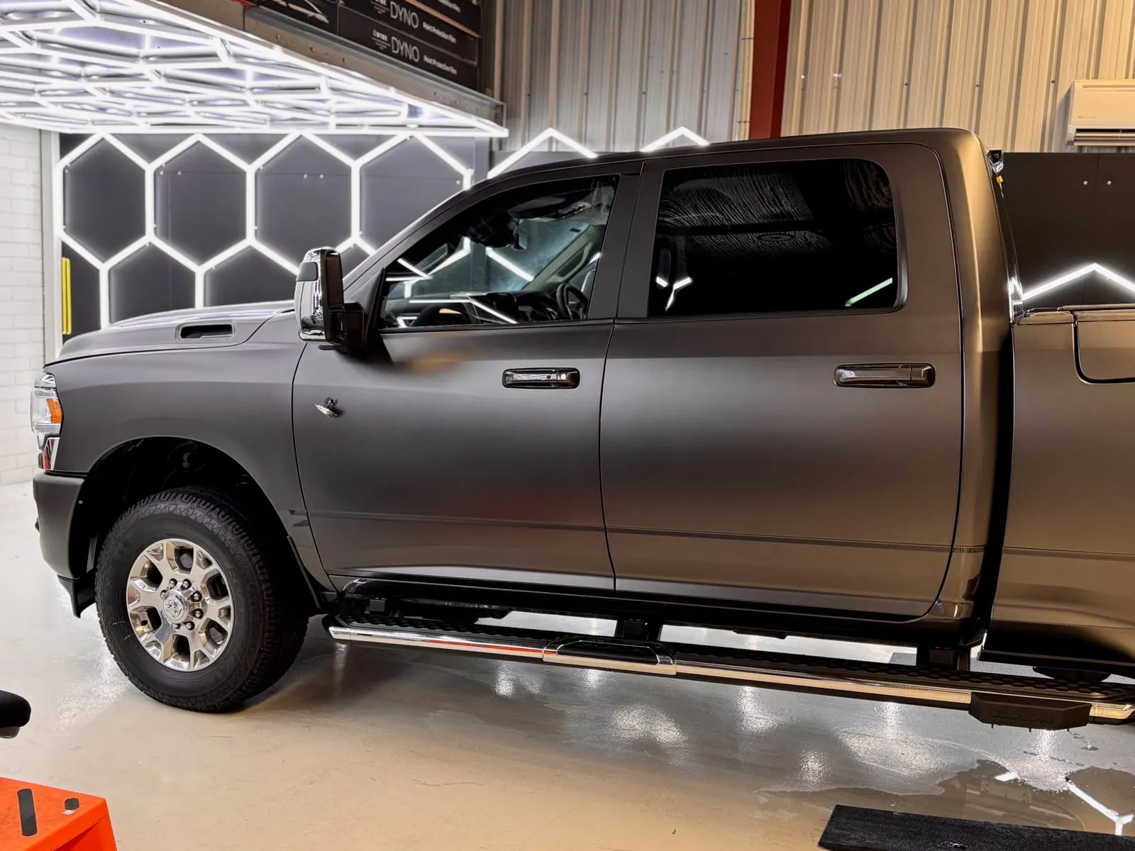 RAM pickup in a satin bronze colour change wrap parked in the studio bay beside the hexagon light wall