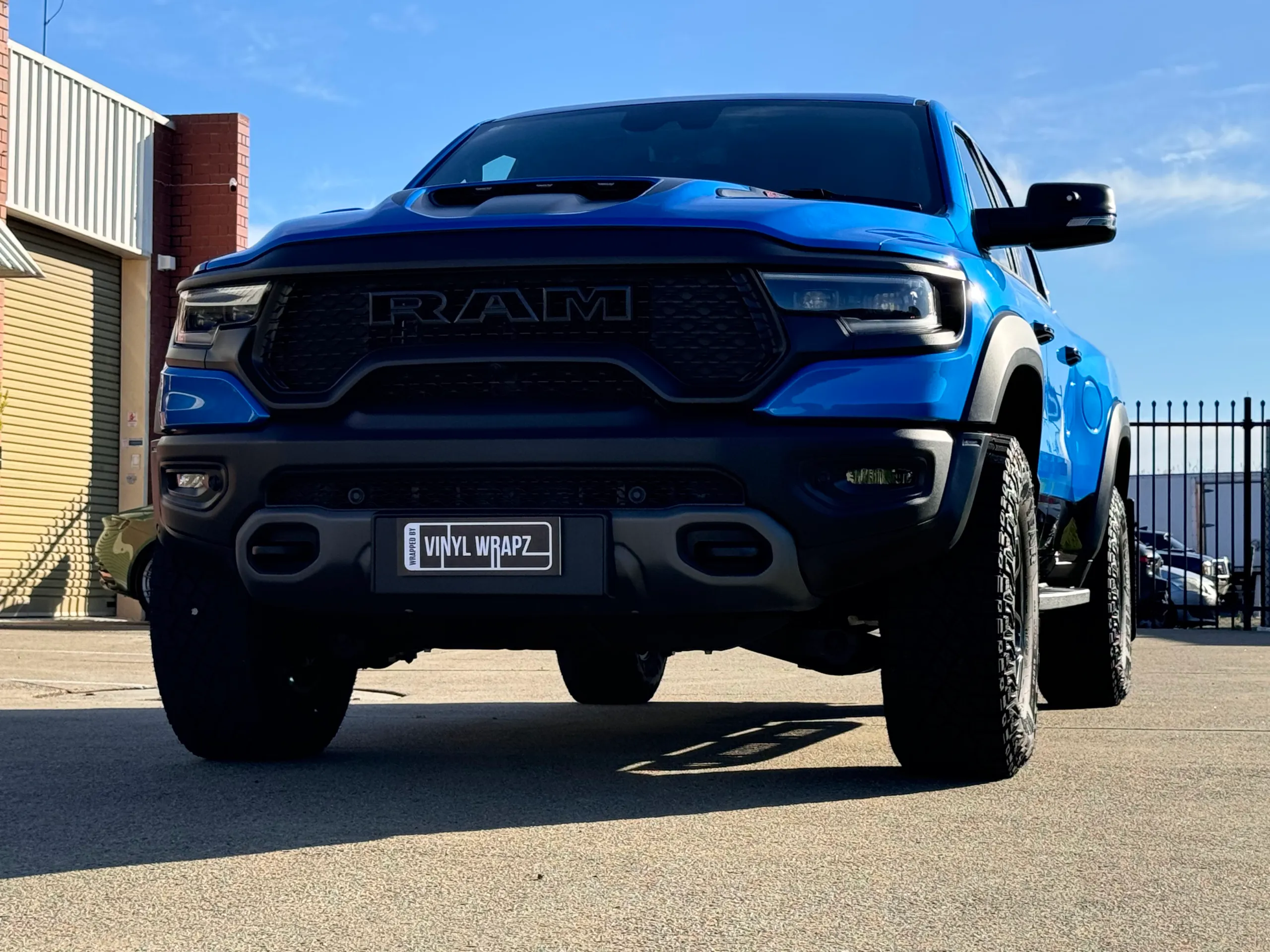 Low front view of the blue Ram TRX grille and bonnet scoop