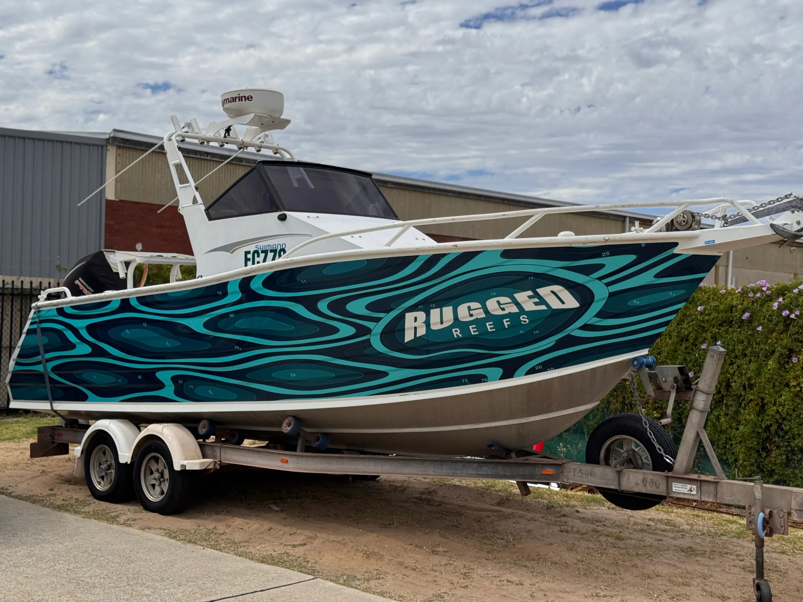 Rugged Reefs boat on its trailer with a custom printed hull wrap by Vinyl Wrapz, Perth
