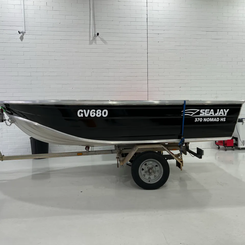 Gloss black Sea Jay 370 Nomad HS dinghy on its trailer inside the workshop