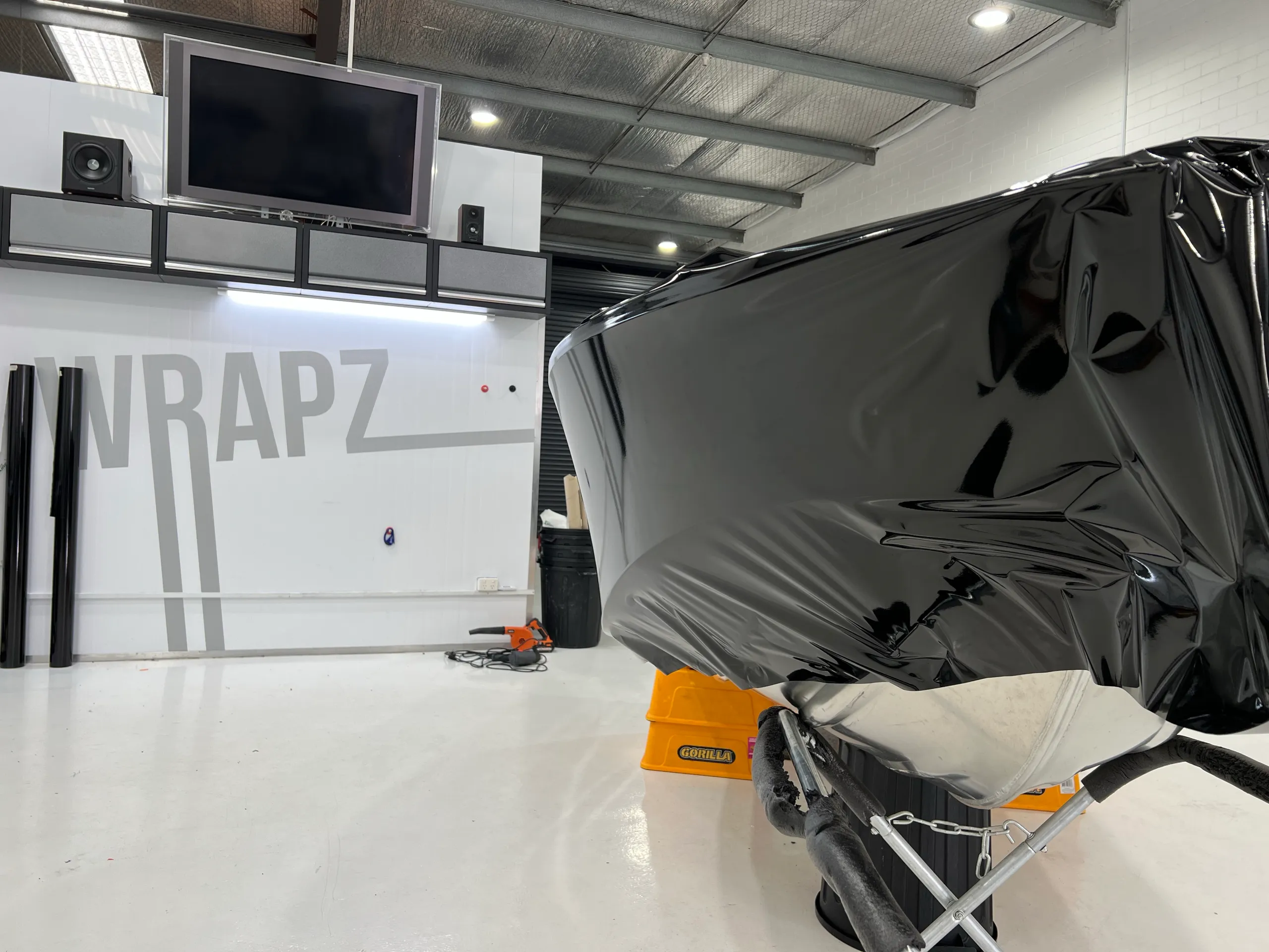 Loose black wrap film stretched around the dinghy bow during installation