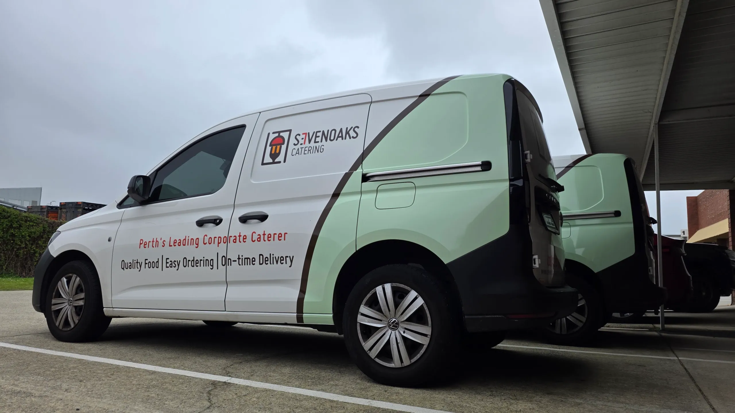 Low side view of a white and mint green Sevenoaks Catering Volkswagen Caddy