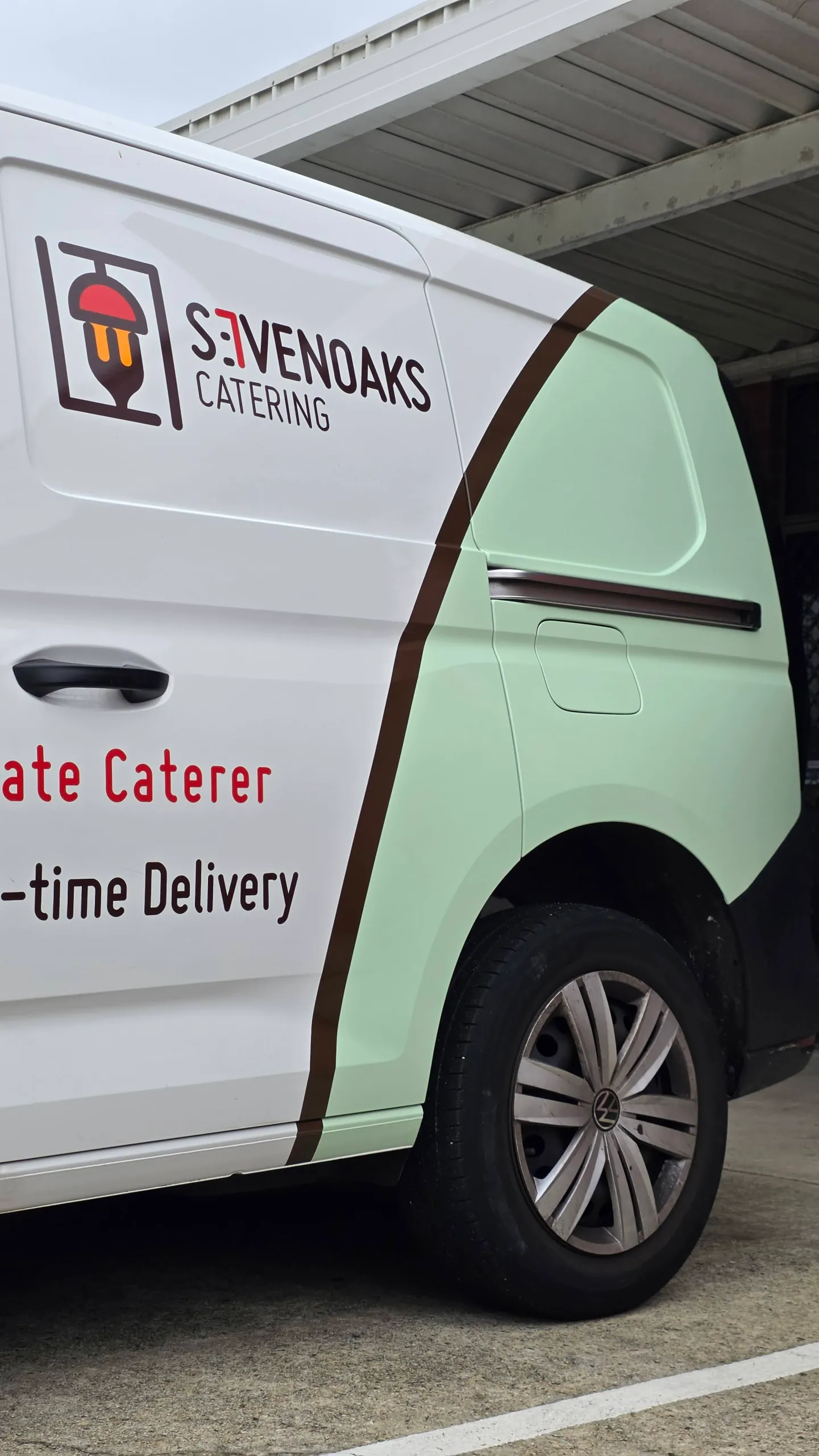Sevenoaks Catering logo and mint green graphics above the Volkswagen Caddy rear wheel