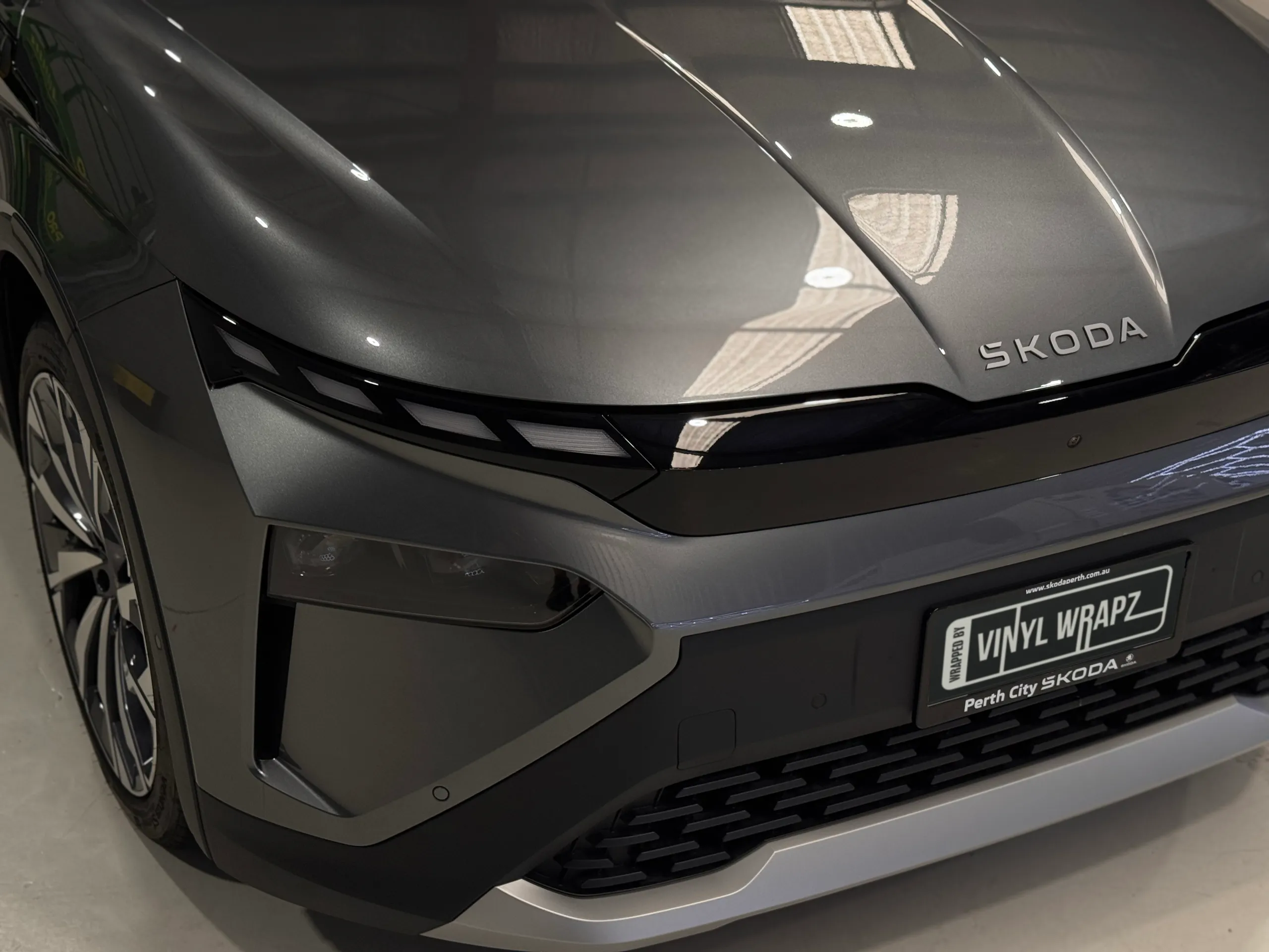 Grey Skoda Elroq bonnet, front lighting and bumper inside the workshop