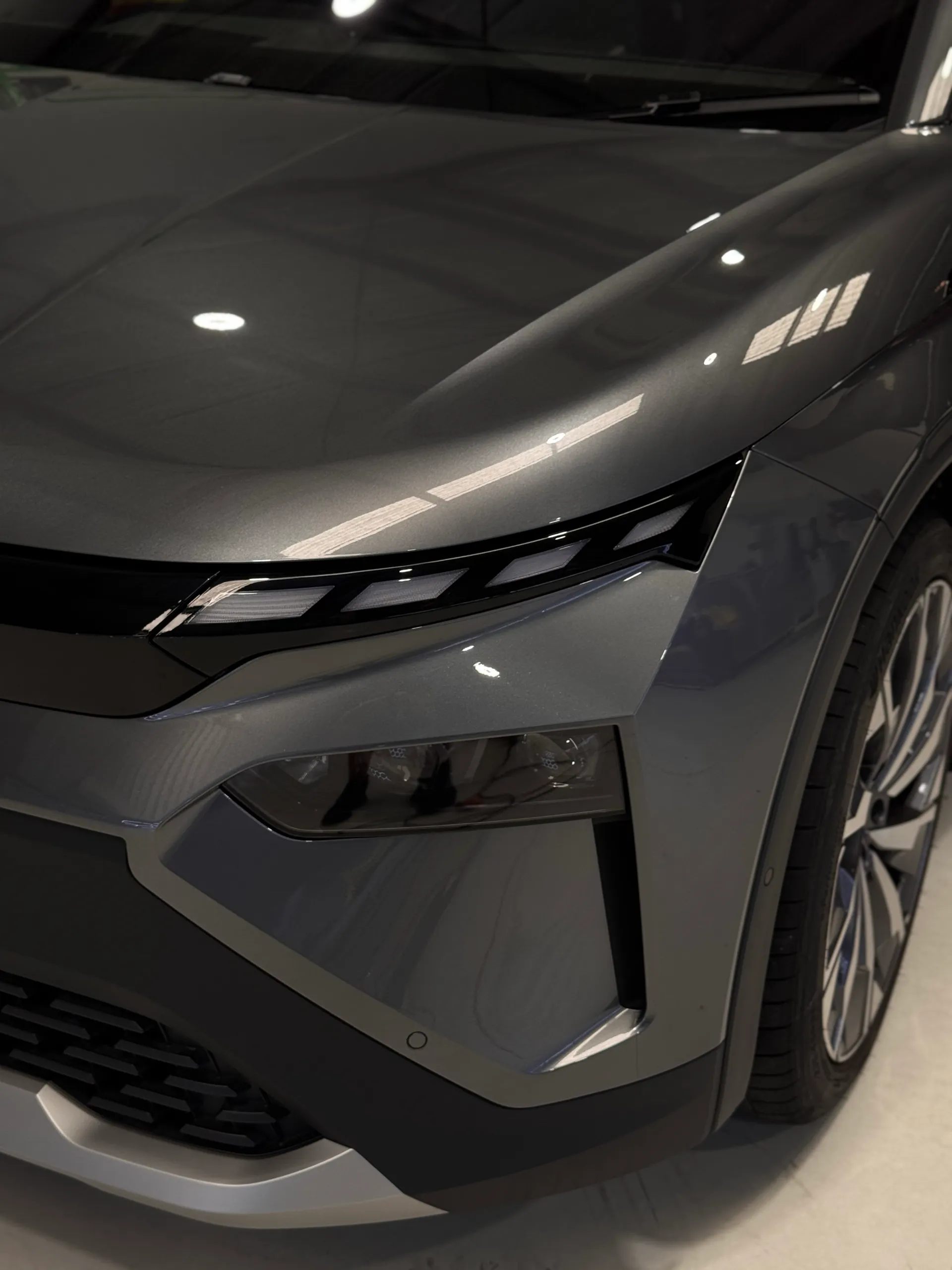 Grey Skoda Elroq front light, guard and bumper in a cropped workshop photograph