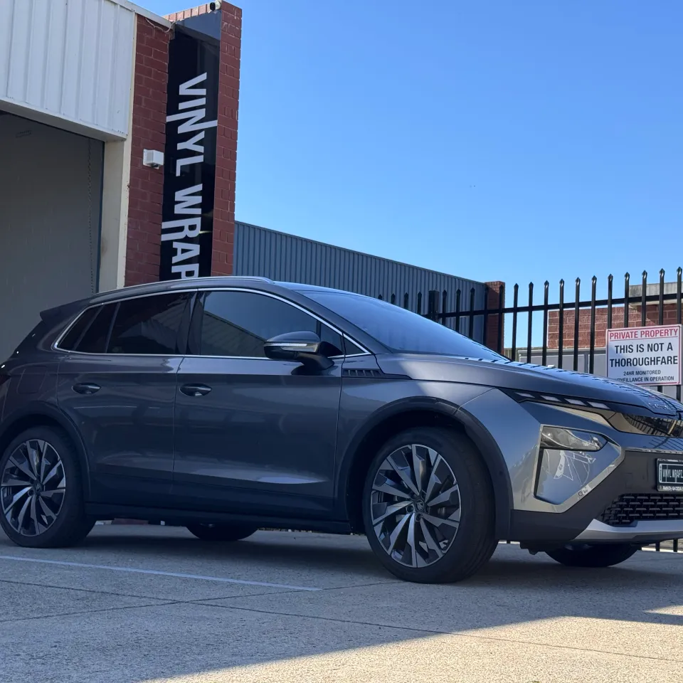Grey Skoda Elroq parked outside the Vinyl Wrapz workshop, viewed from the front quarter