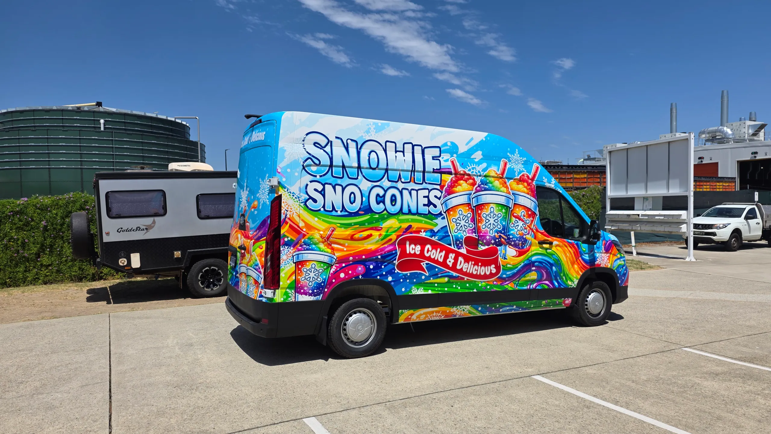 Snowie Sno Cones van with a colourful full wrap, viewed from the side and rear outdoors