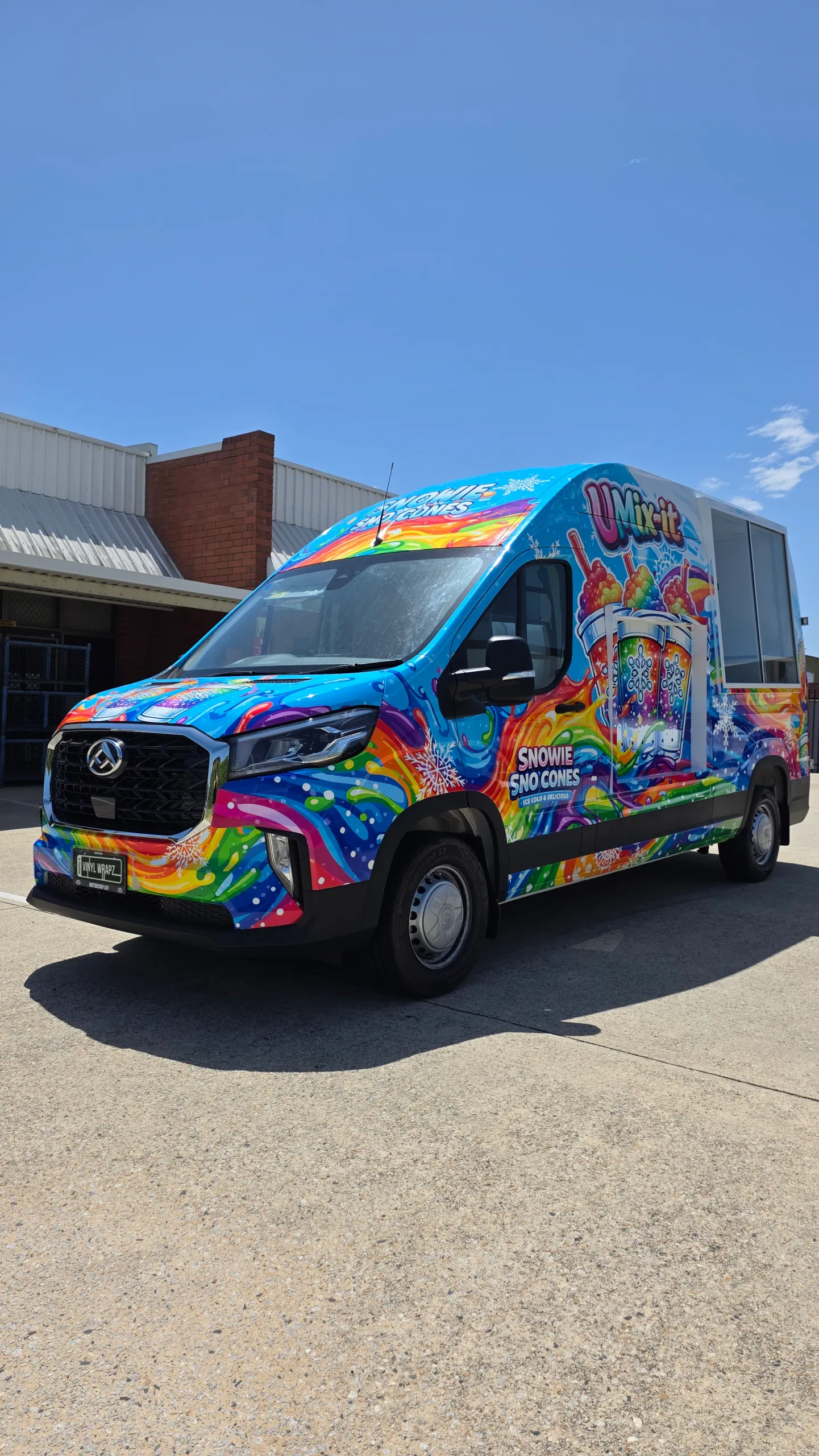 Snowie Sno Cones LDV van viewed from the front quarter, with rainbow graphics across its cab and side