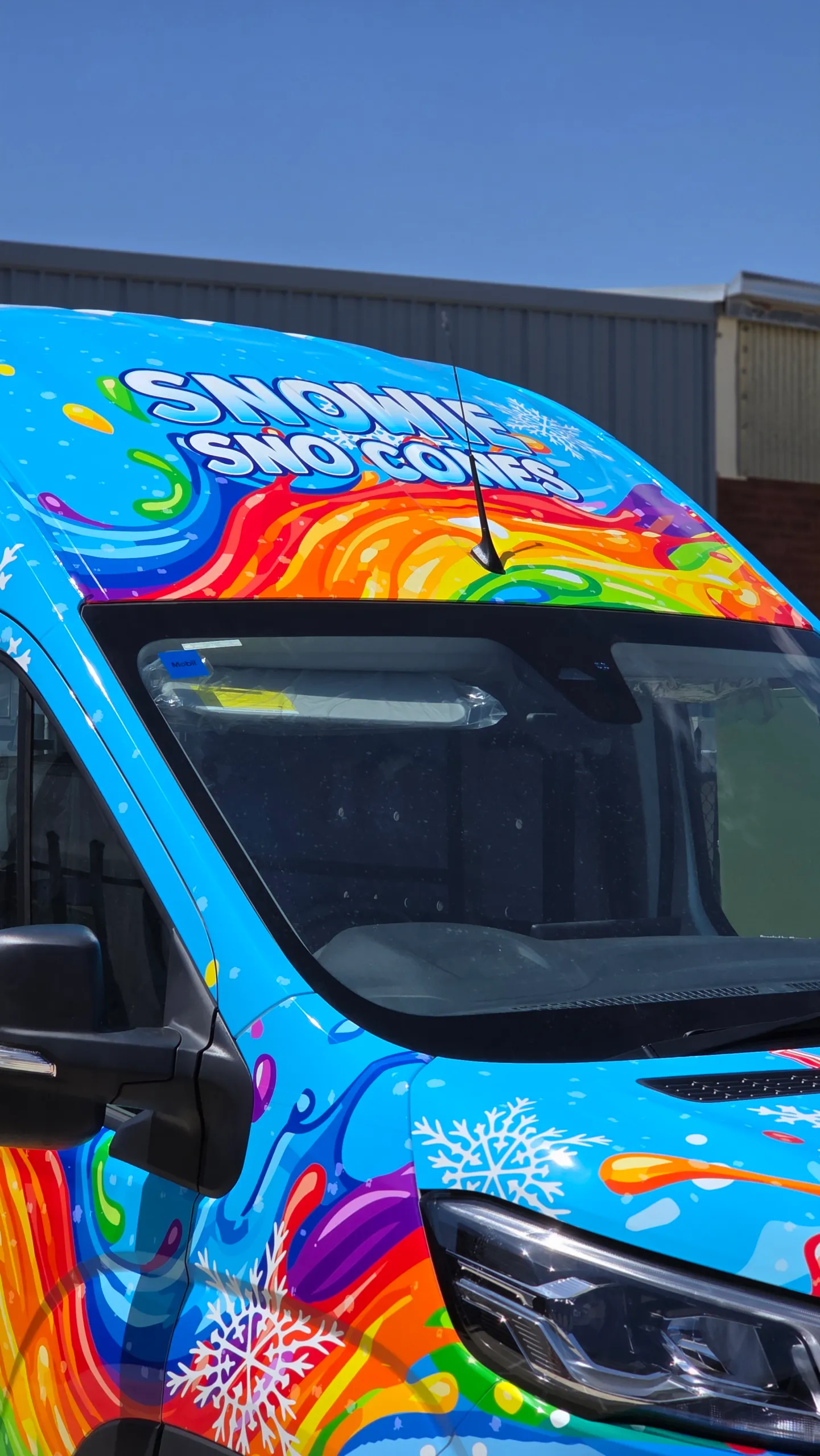Snowie Sno Cones lettering above the windscreen, with rainbow graphics across the van bonnet