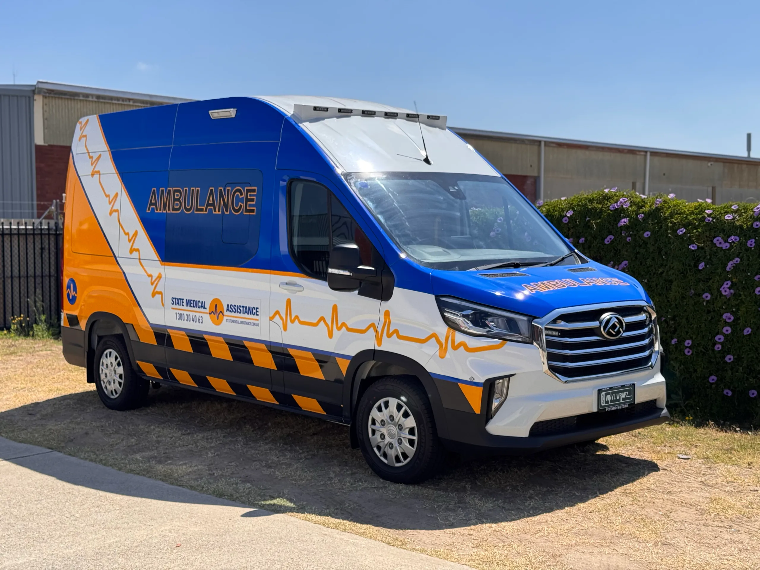State Medical Assistance LDV ambulance with blue and yellow graphics outside the workshop