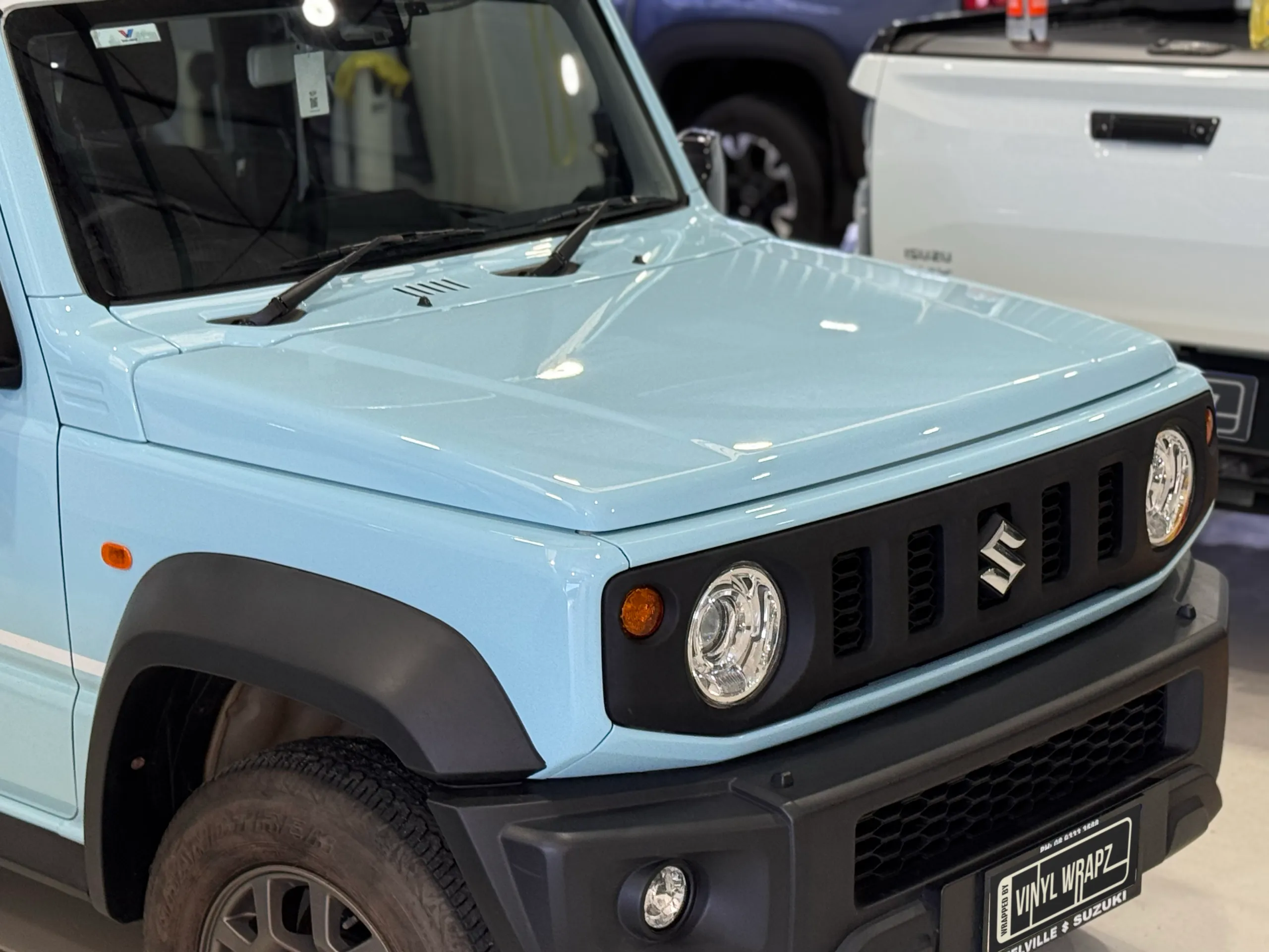 Finished light blue bonnet and front grille on the Suzuki Jimny in the workshop