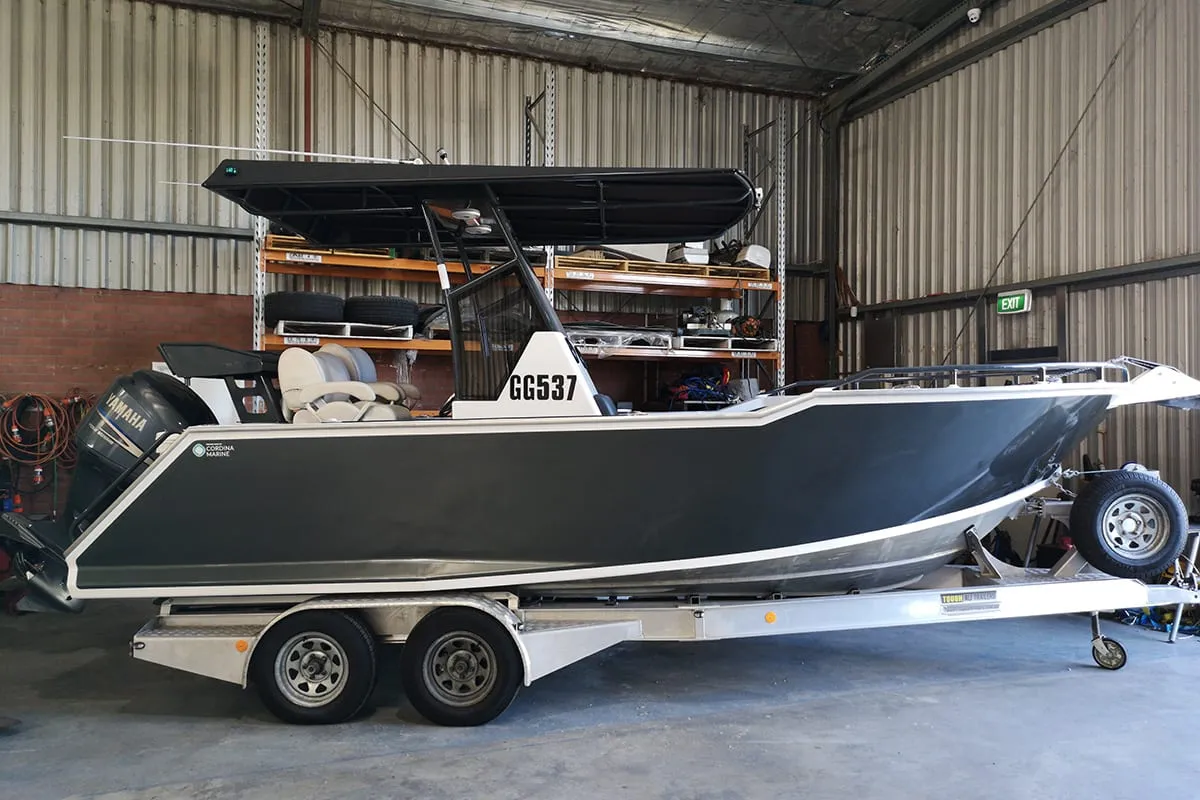 7 m aluminium Cordina Marine bow rider with a charcoal hull wrap on its trailer in the workshop