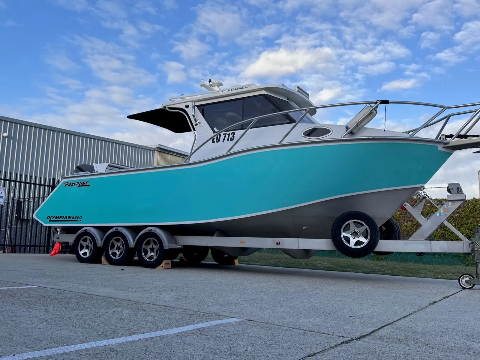 Razerline Olympian 8500 cabin cruiser in a gloss teal hull colour change wrap on its trailer outside the Vinyl Wrapz workshop, Perth