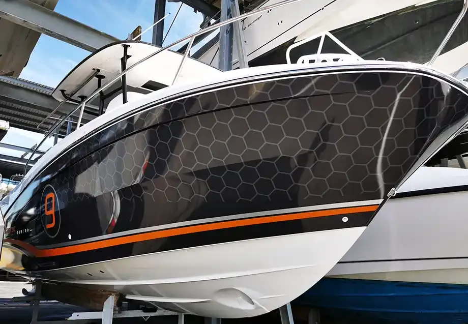 Jeanneau Cap Camarat 8 with a custom printed black hexagon hull wrap and orange stripe, Perth