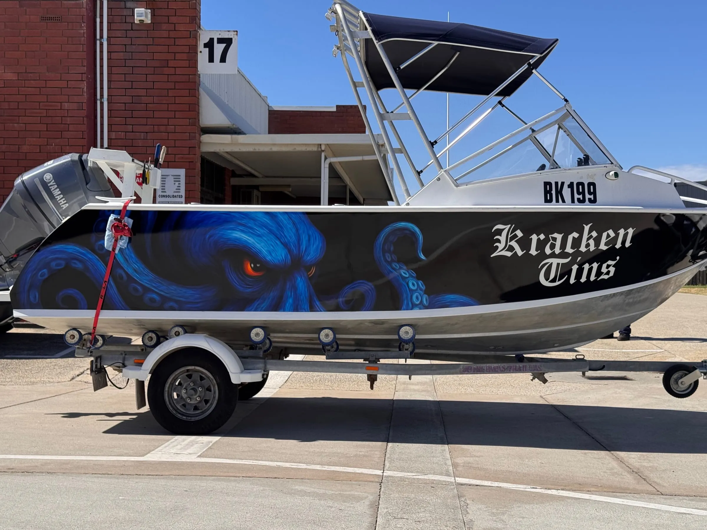 Custom printed boat wrap with blue octopus artwork on a black hull, Perth