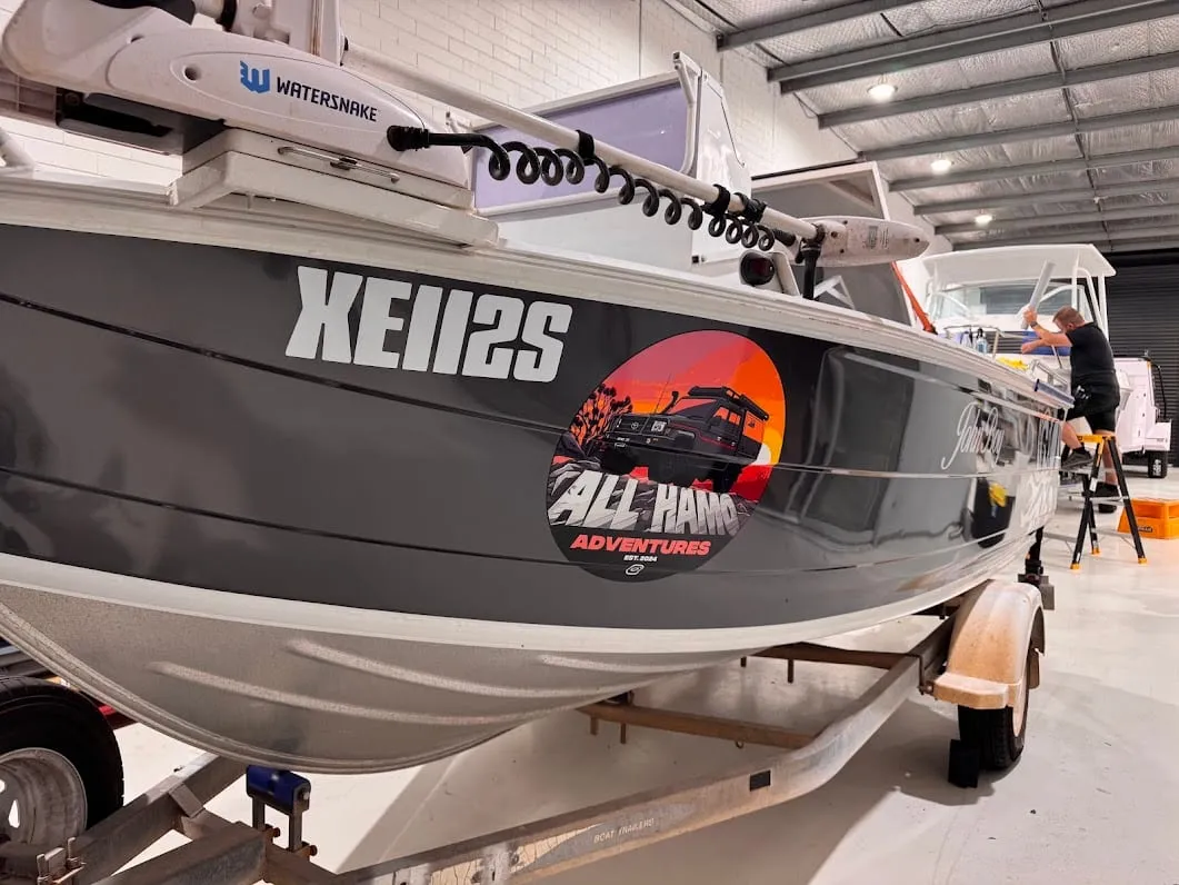 Aluminium boat in a satin grey hull wrap with printed logo graphics outside the Vinyl Wrapz workshop, Osborne Park