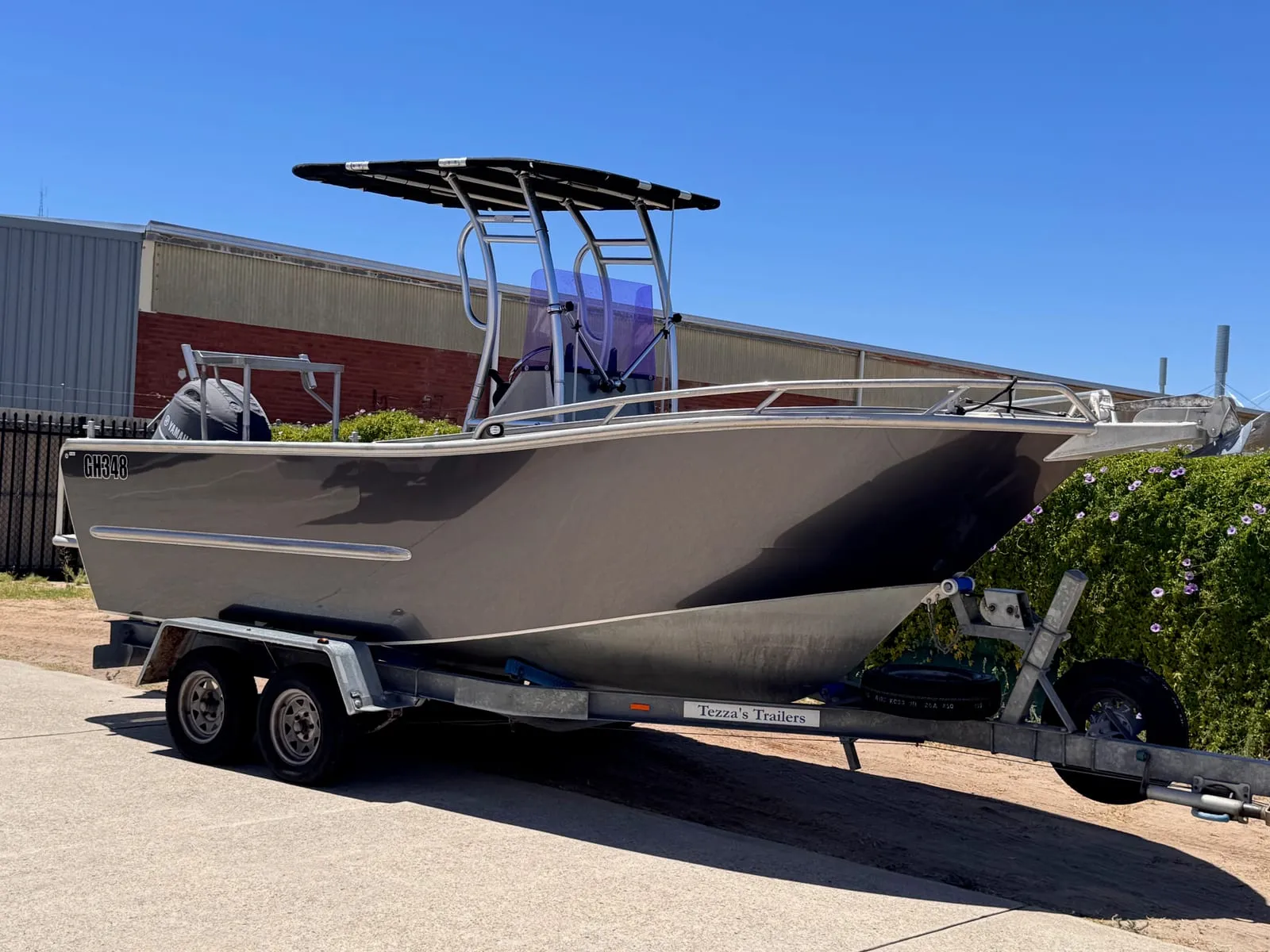 Satin gunmetal grey aluminium centre-console fishing boat on its trailer outside the Vinyl Wrapz workshop, Perth