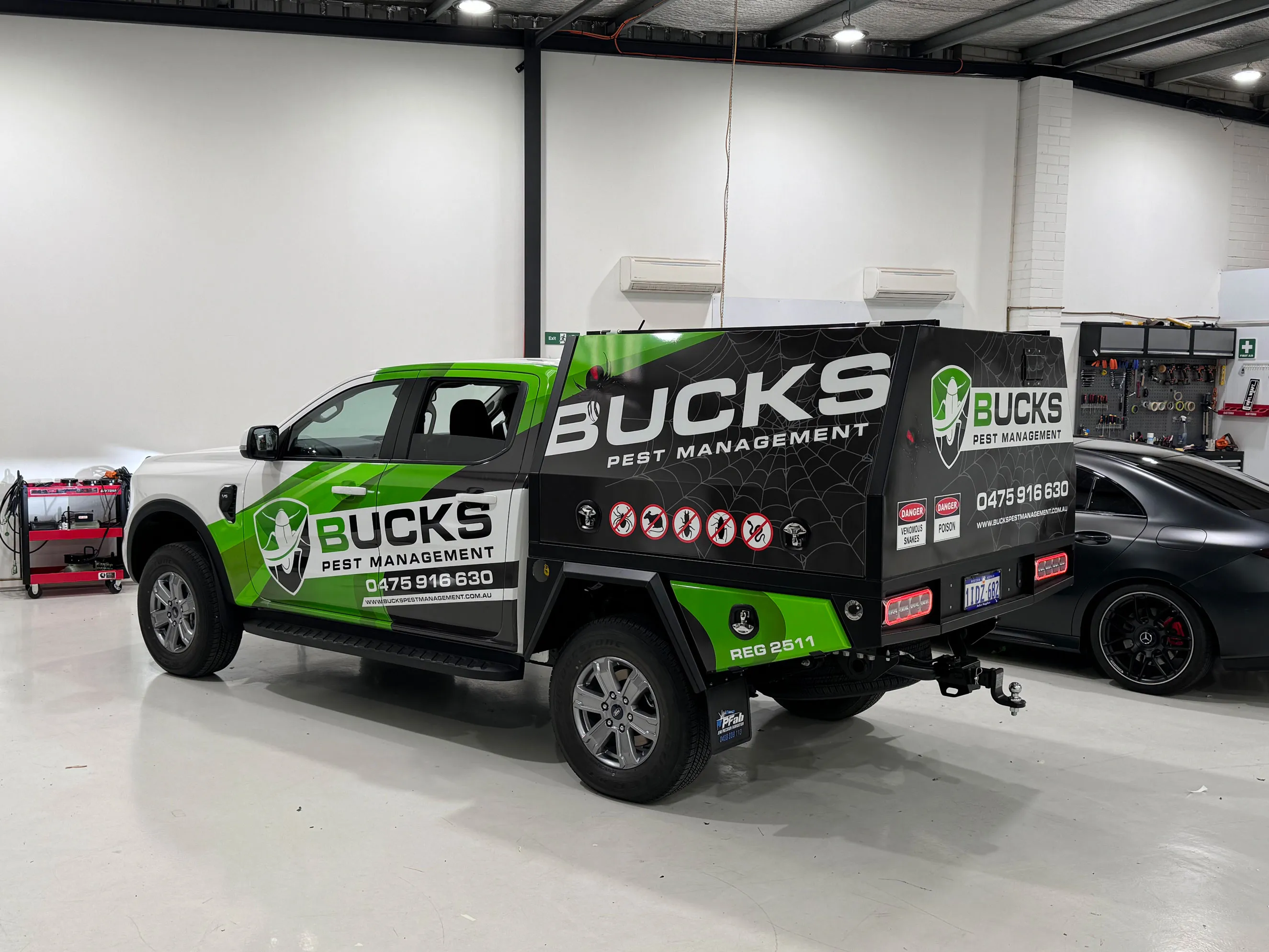 Bucks Pest Management ute with printed canopy graphics in the workshop