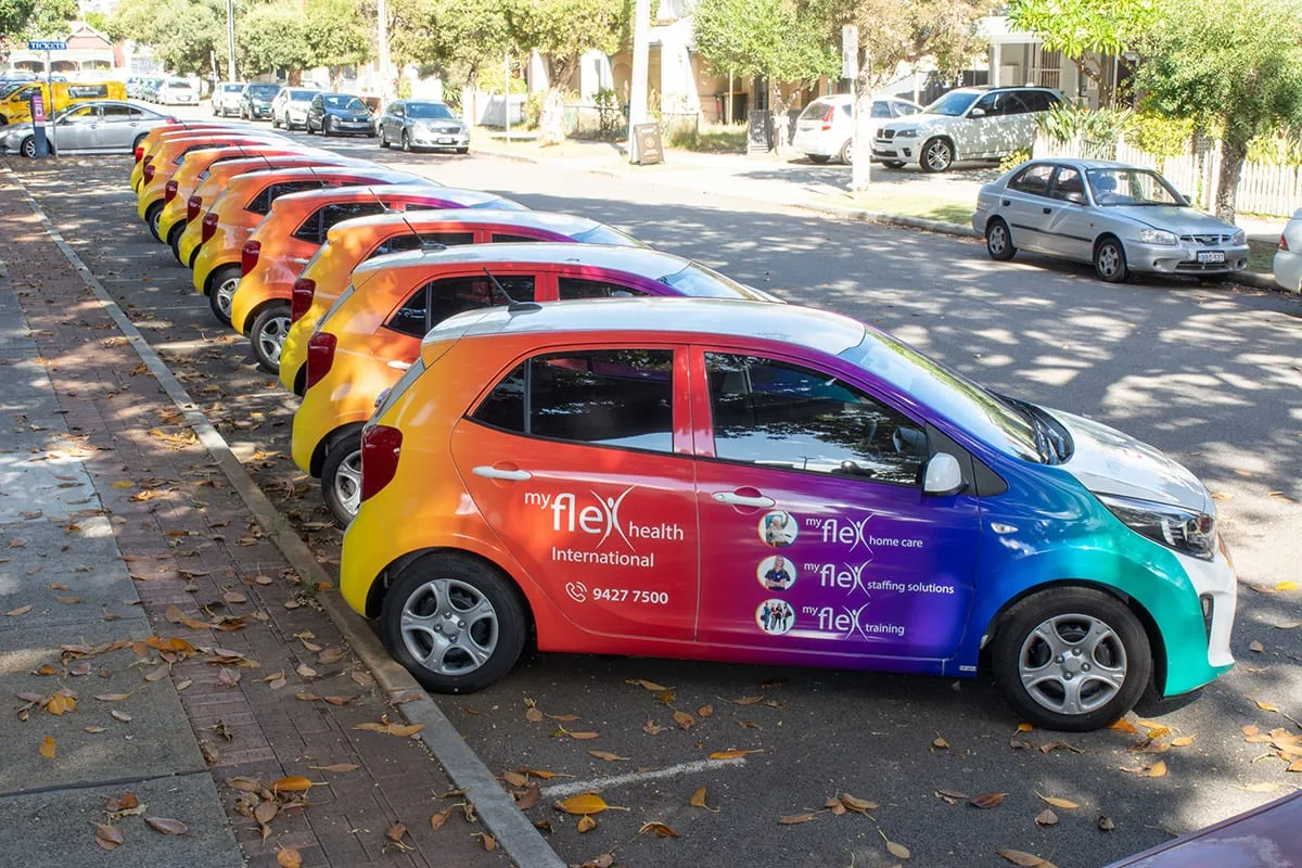 Row of My Flex Health Kia Picanto fleet cars in matching rainbow gradient wraps by Vinyl Wrapz