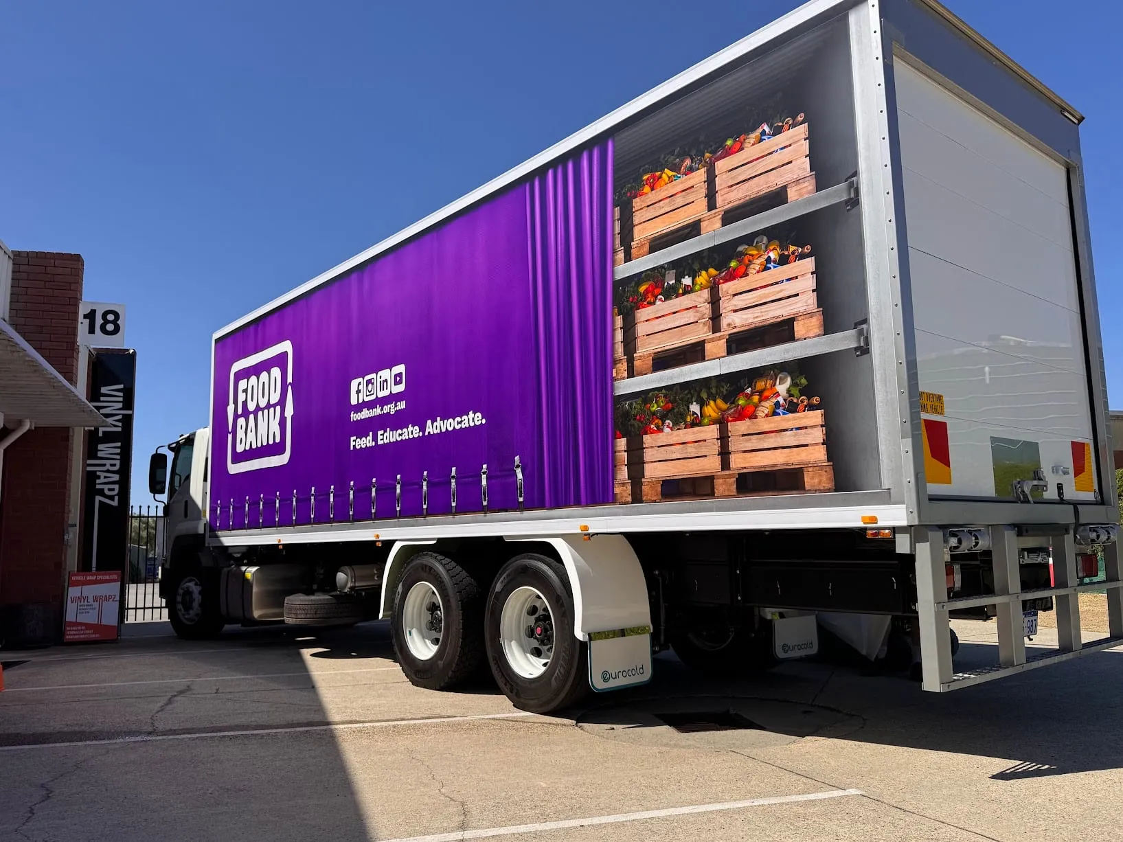 Foodbank Perth truck with printed curtain-side wrap showing stacked produce crates