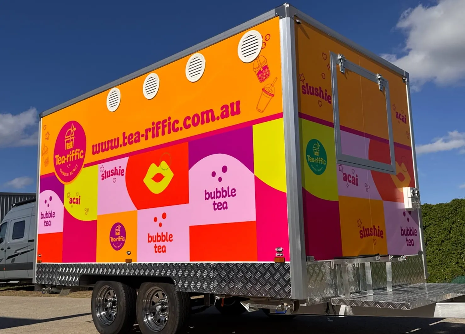 Tea-riffic bubble tea trailer in a bright orange and pink printed wrap