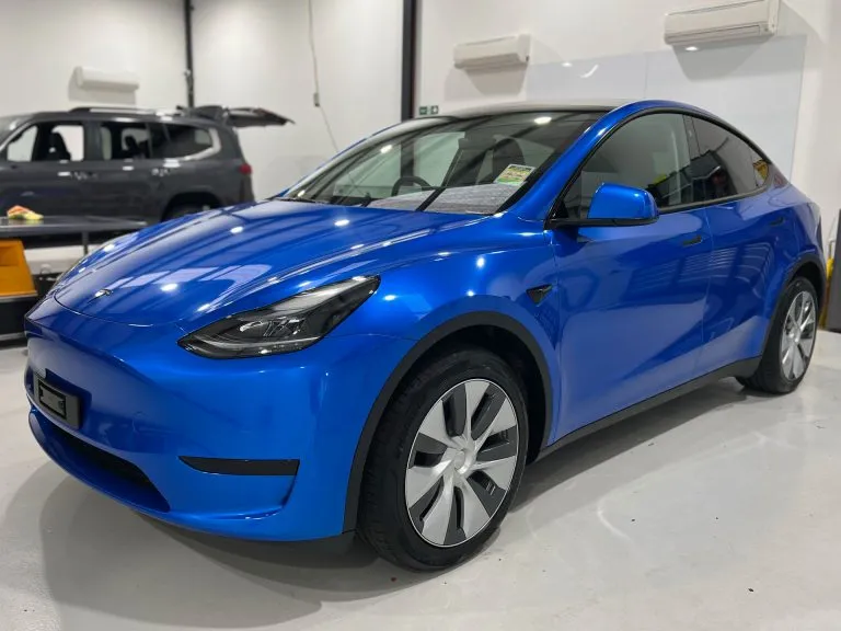 Tesla Model Y in a gloss blue colour change wrap inside the Vinyl Wrapz workshop