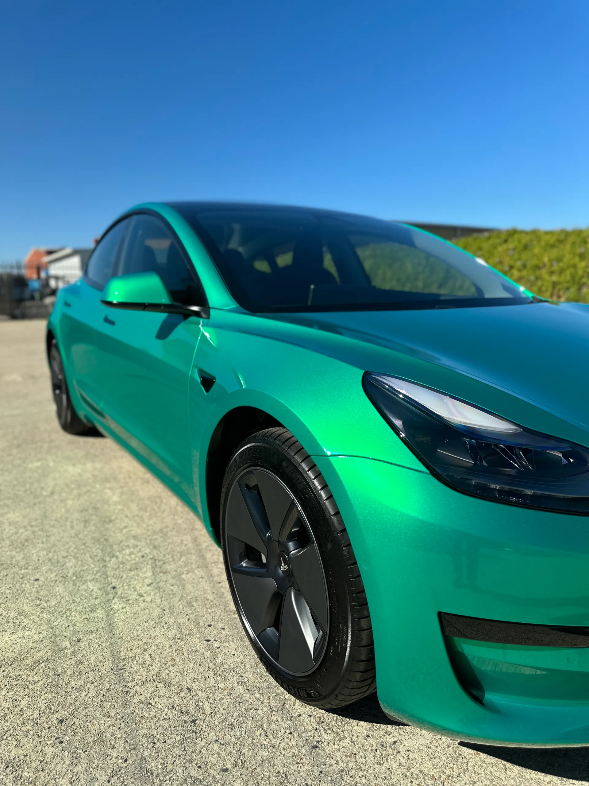 Envious green Tesla Model 3, front detail