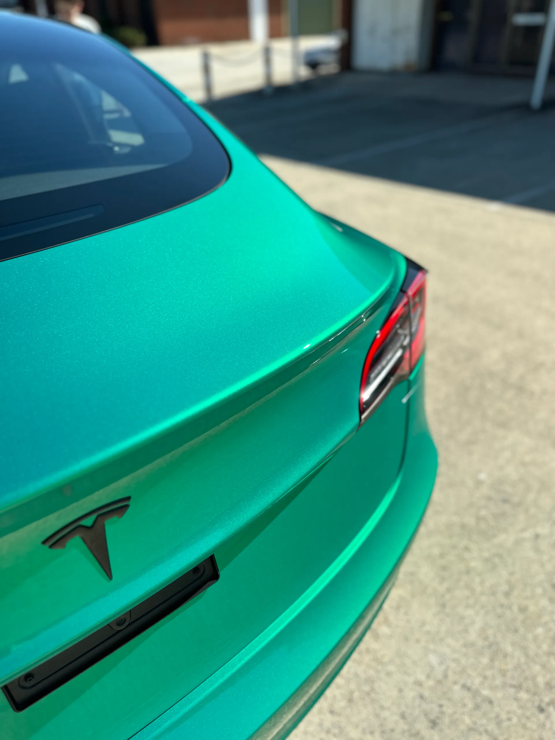 Envious green Tesla Model 3, rear detail