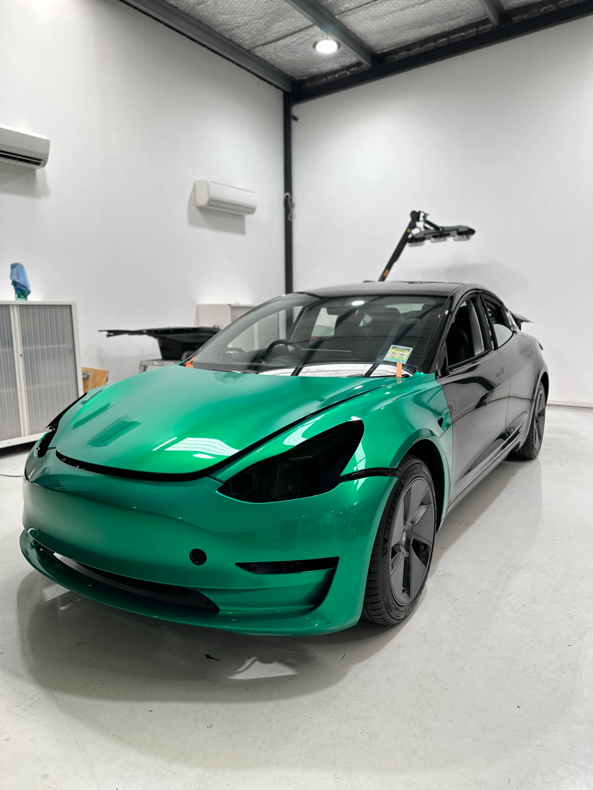 Envious green Tesla Model 3, front quarter