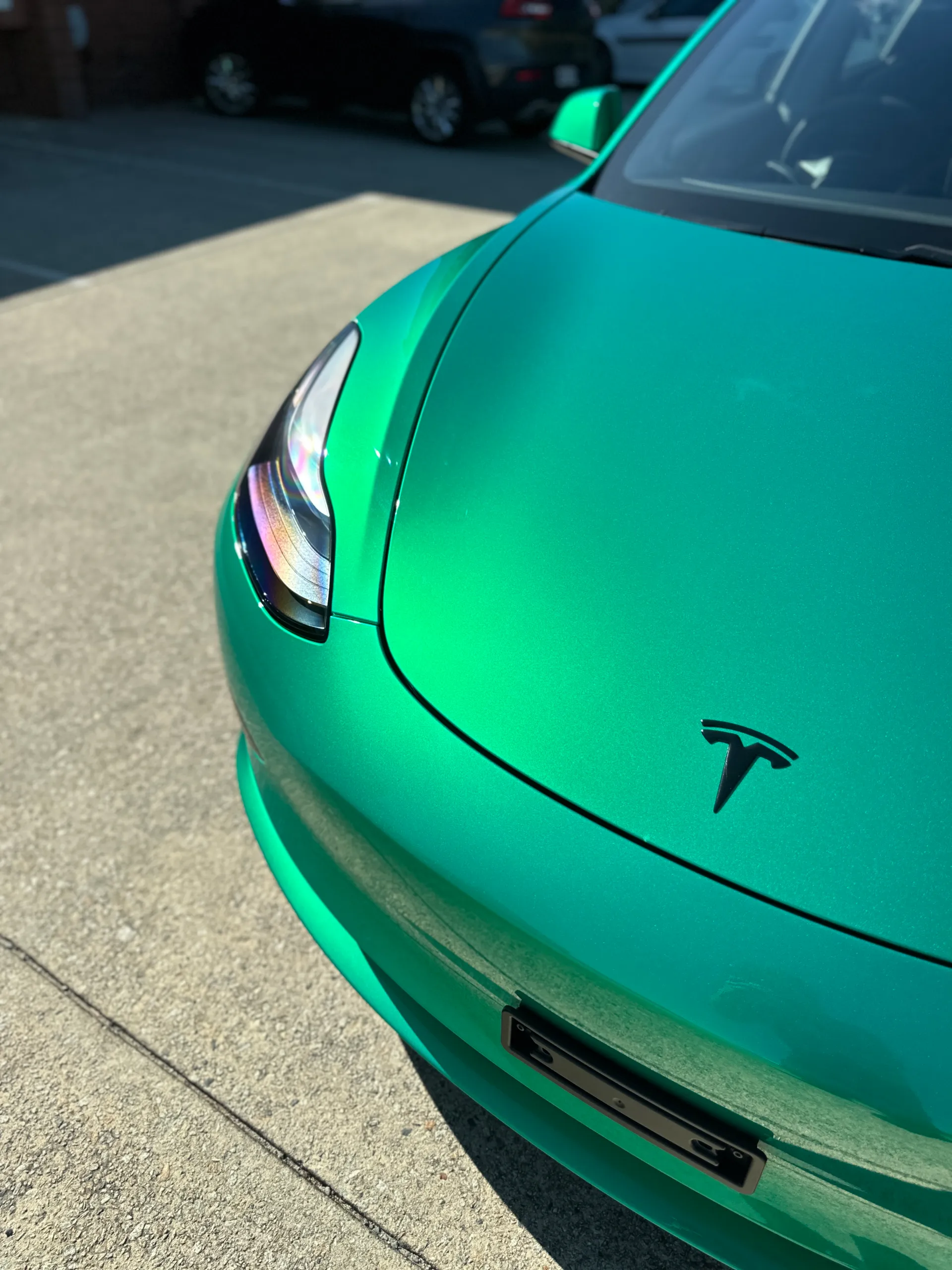 Envious green Tesla Model 3, front detail