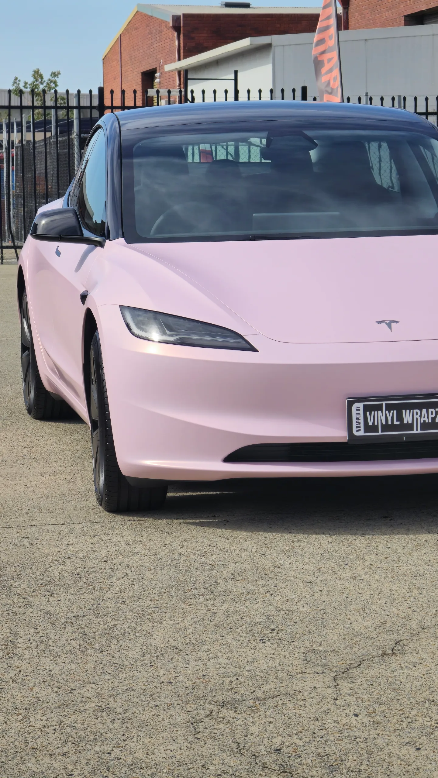 Pale pink satin Tesla Model 3 with black roof and wheels, front detail