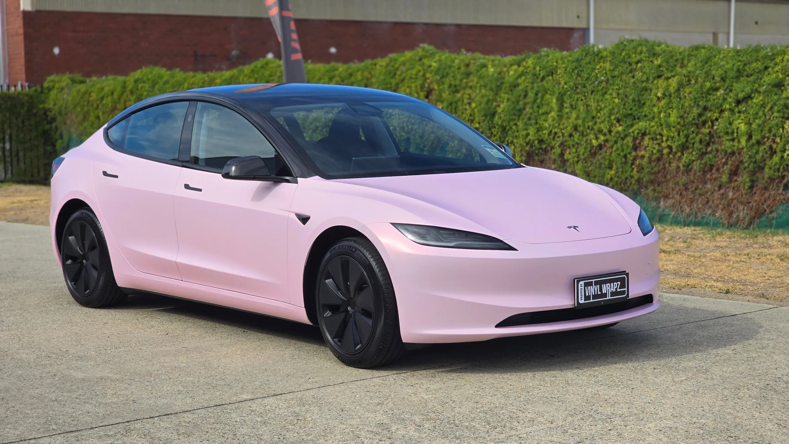 Pale pink satin Tesla Model 3 with black roof and wheels, front quarter