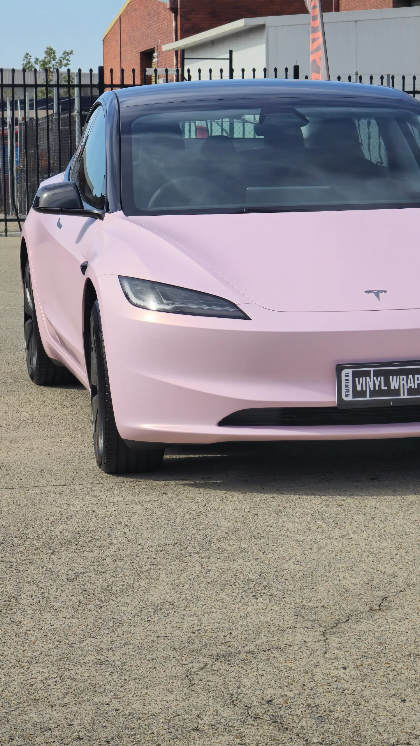 Pale pink satin Tesla Model 3 with black roof and wheels, front detail