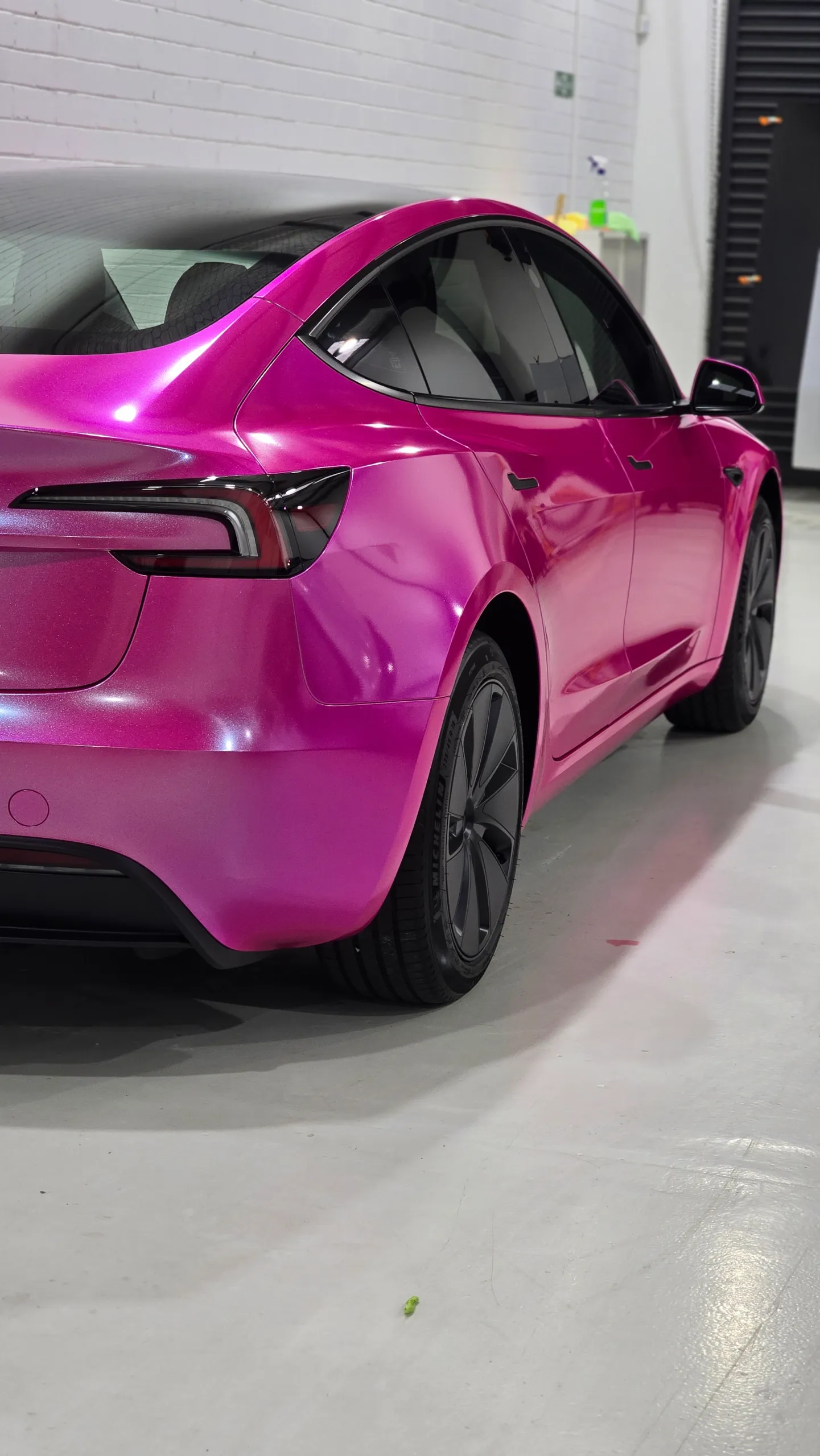 Pink Tesla Model 3 rear quarter and side panels inside the workshop