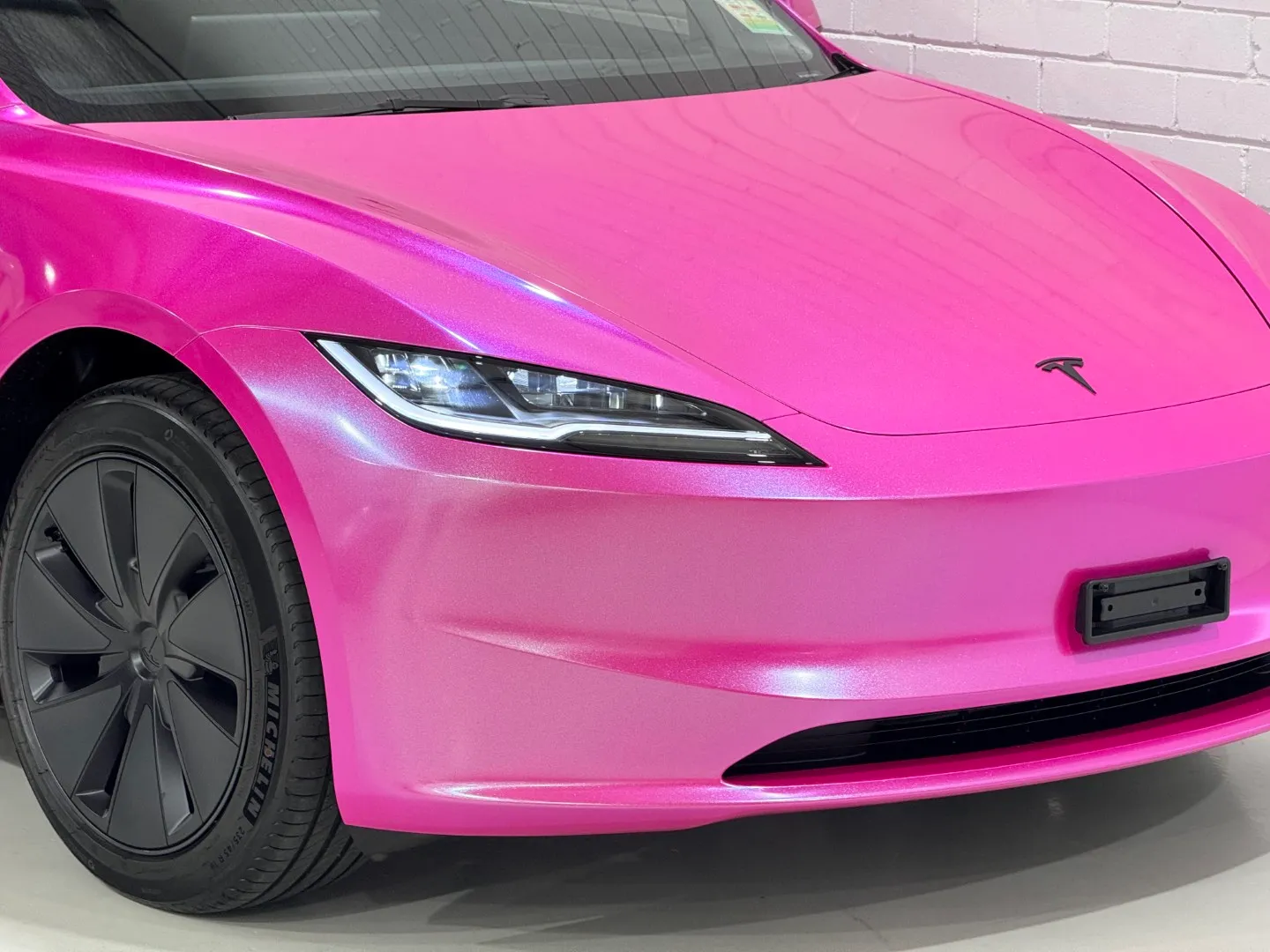 Pink Tesla Model 3 bonnet and headlight with blue highlights across the finish