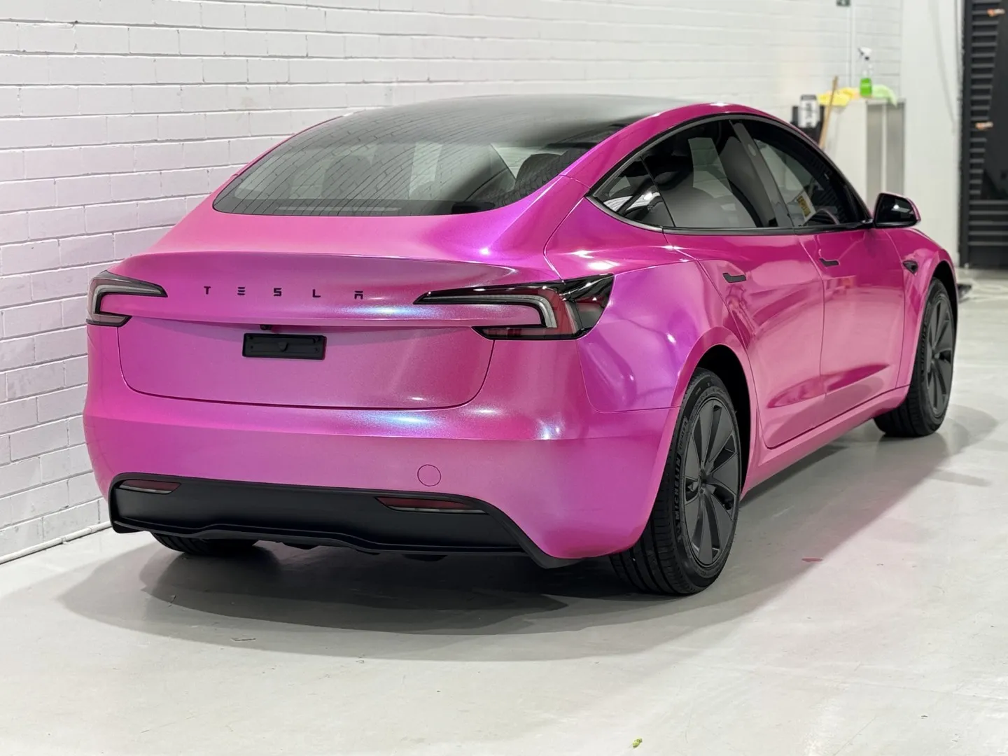 Pink Tesla Model 3 rear quarter with Tesla lettering across its boot lid