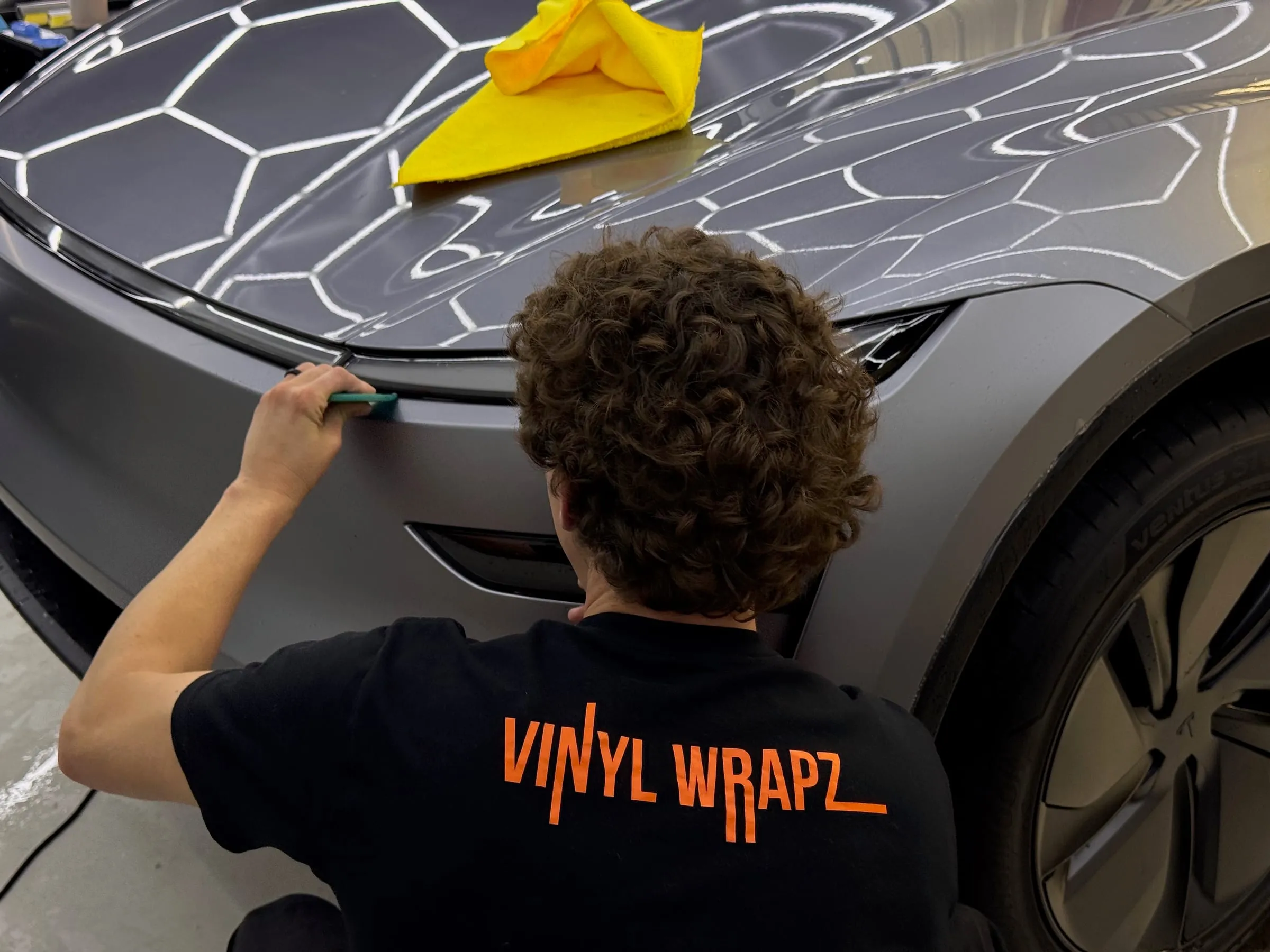 Installer marking the paint protection film template on the bonnet of a Tesla Model 3 at Vinyl Wrapz, Osborne Park