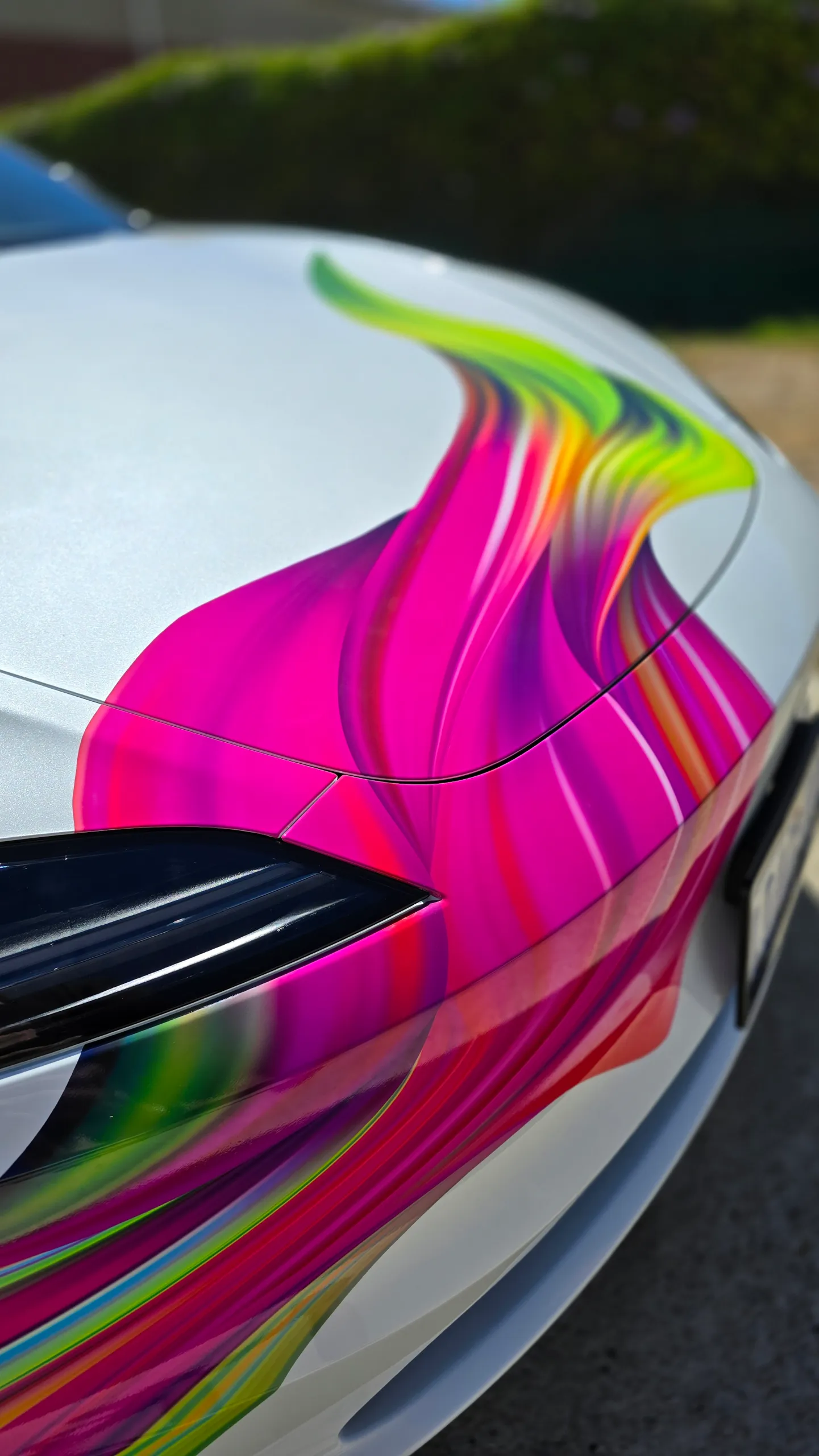 Pink splash artwork across the Tesla bonnet