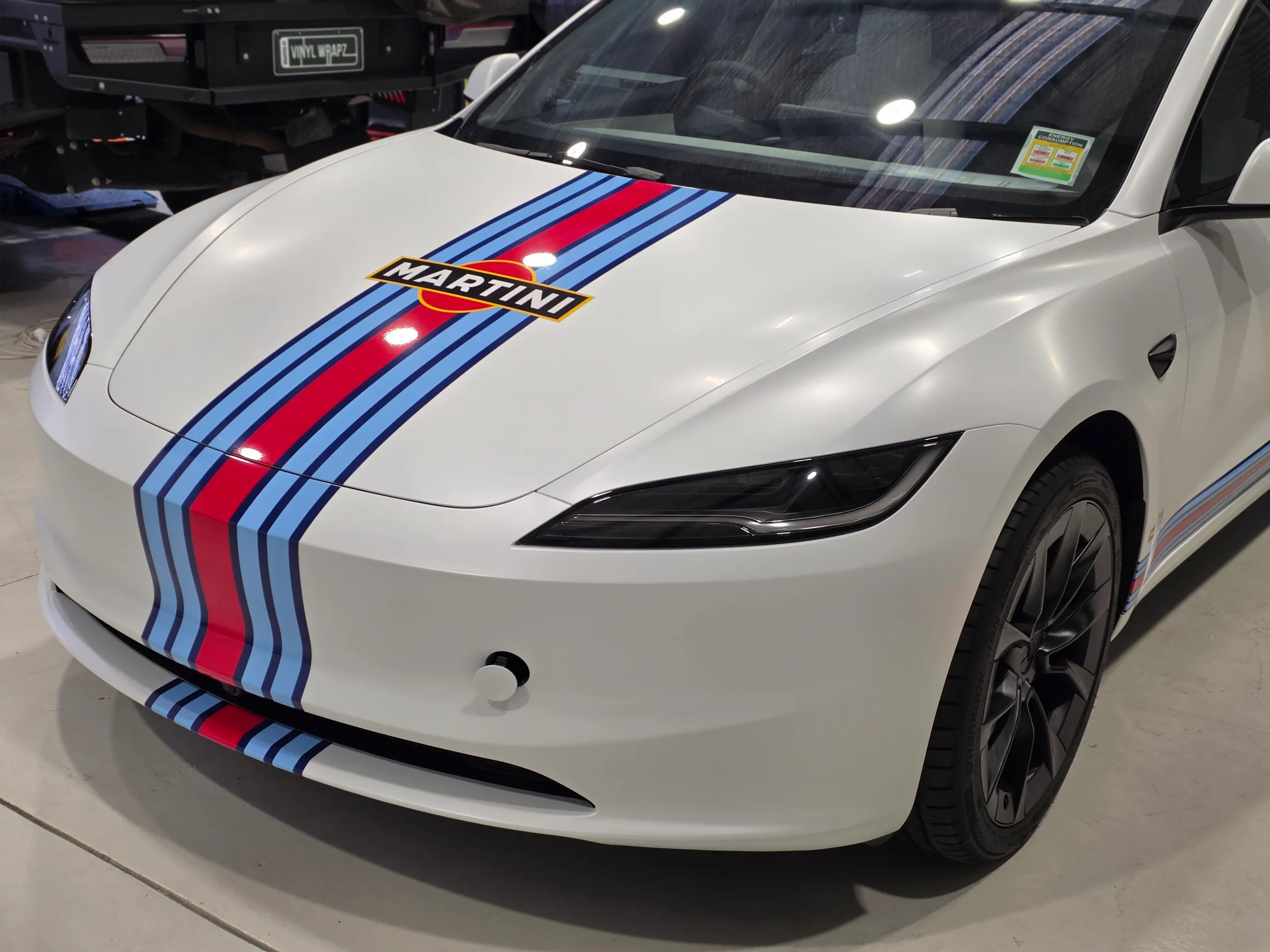 White Tesla Model 3 front end and cabin with red and blue Martini stripes