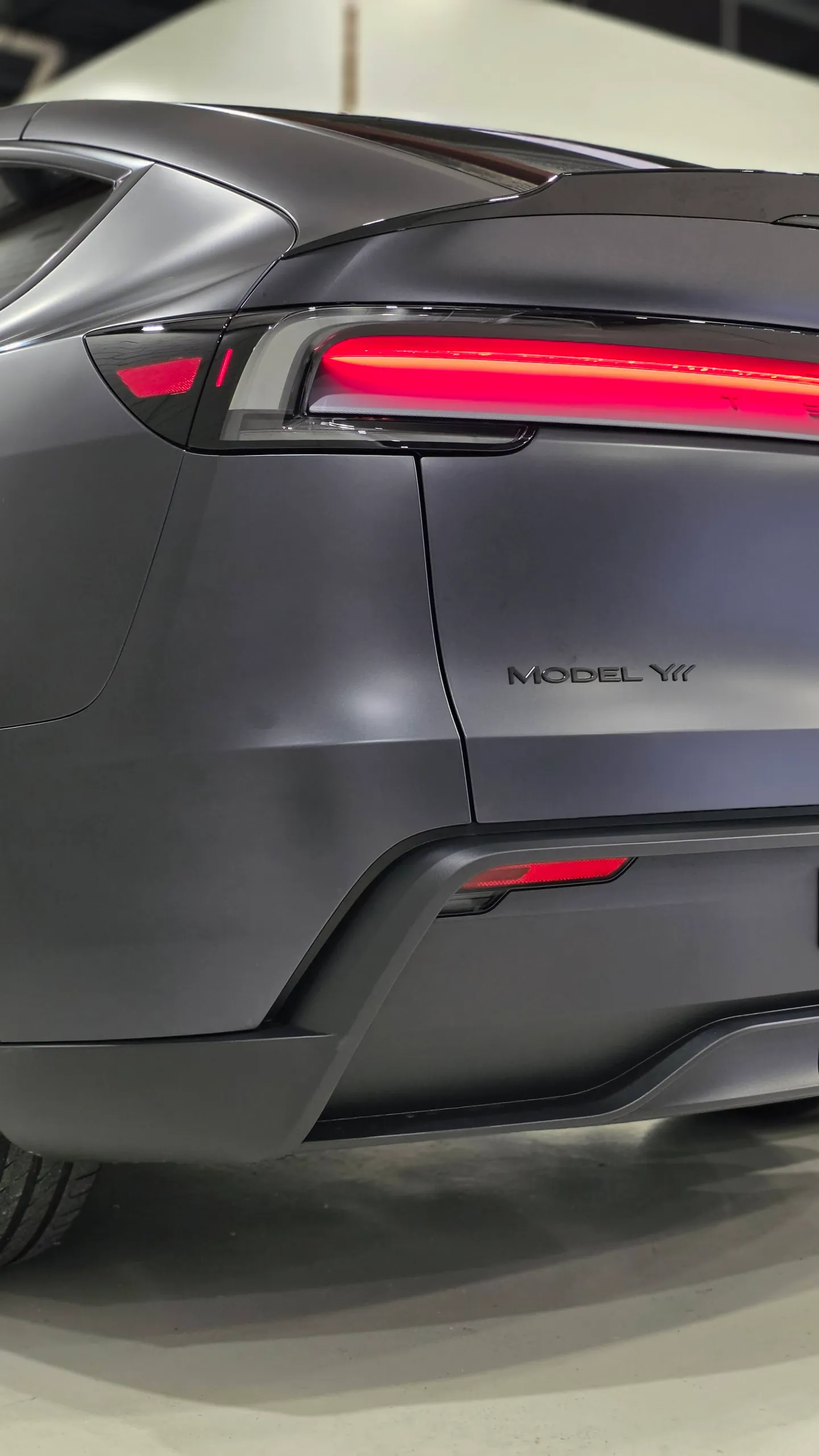 Illuminated rear light and Model Y badge on the matte dark grey Tesla tailgate