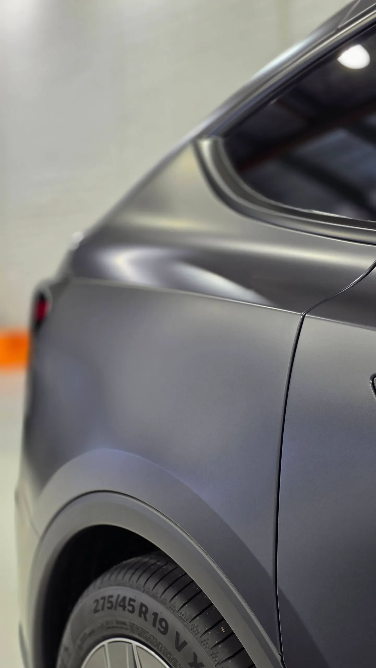 Close-up of the matte dark grey Tesla Model Y rear quarter below the side window