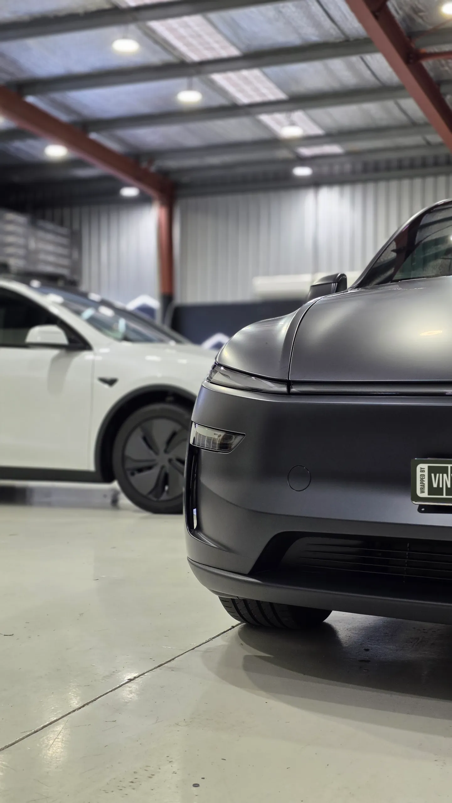 Matte dark grey Tesla Model Y front bumper and bonnet edge in the workshop