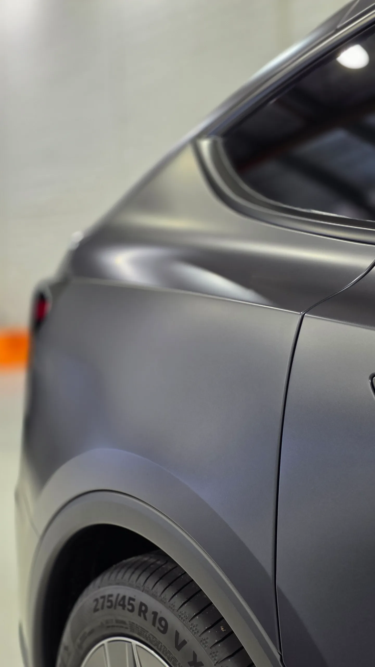 Detail of the matte dark grey Tesla Model Y rear quarter and window edge