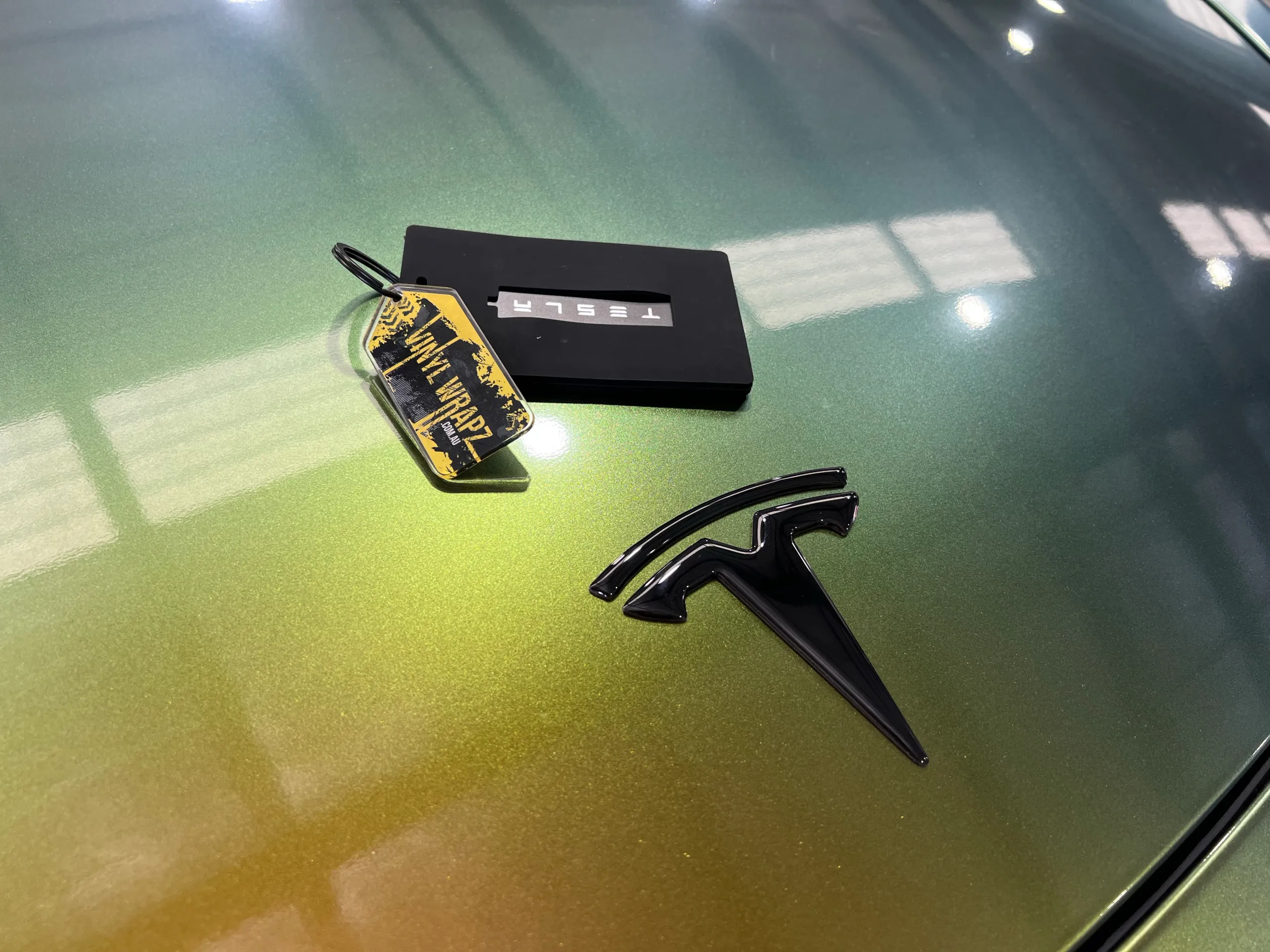 Golden green colour-shift Tesla Model Y, bonnet badge detail